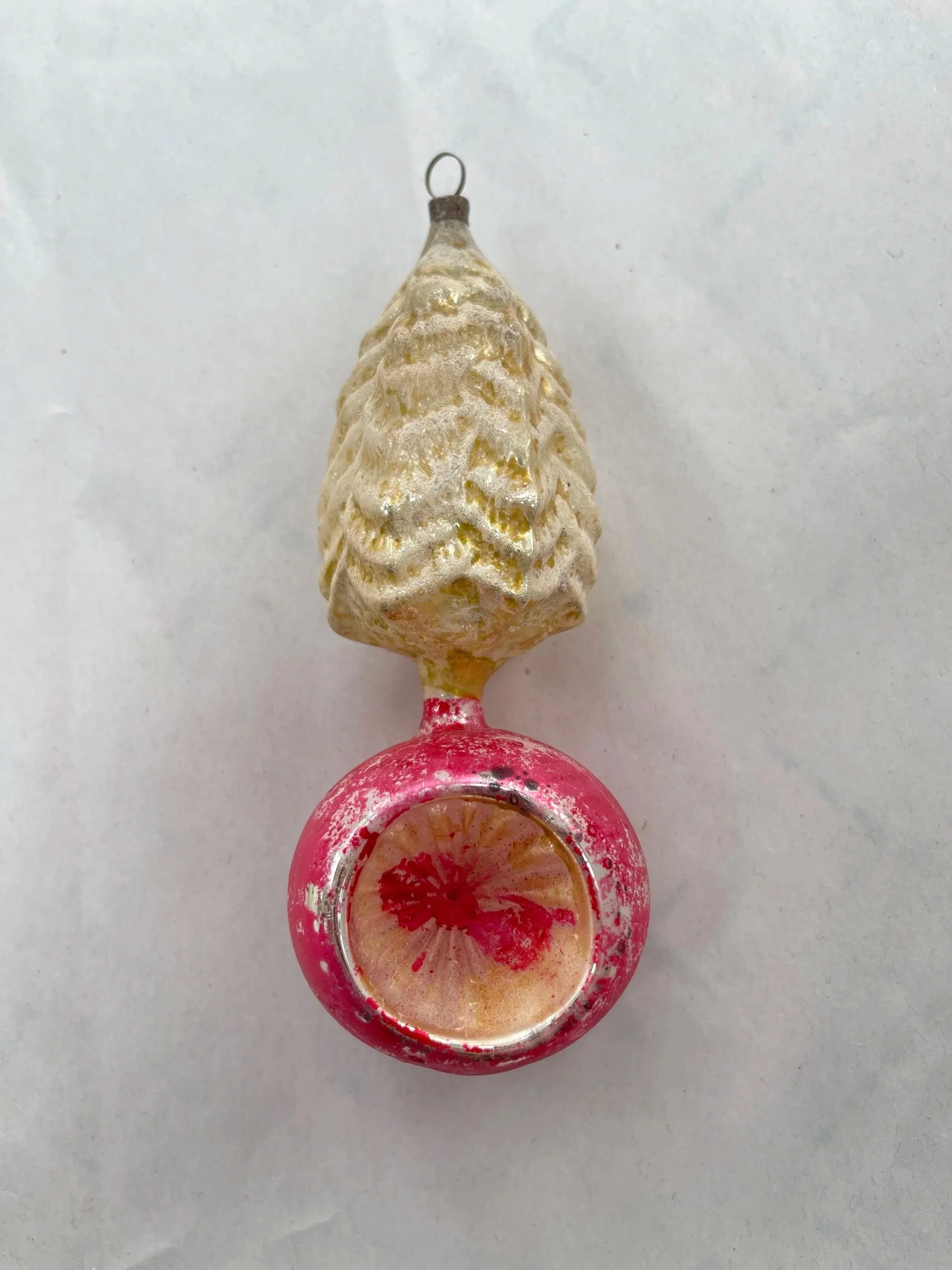 Antique German glass ornament with a gold pinecone top and pink reflector drop.