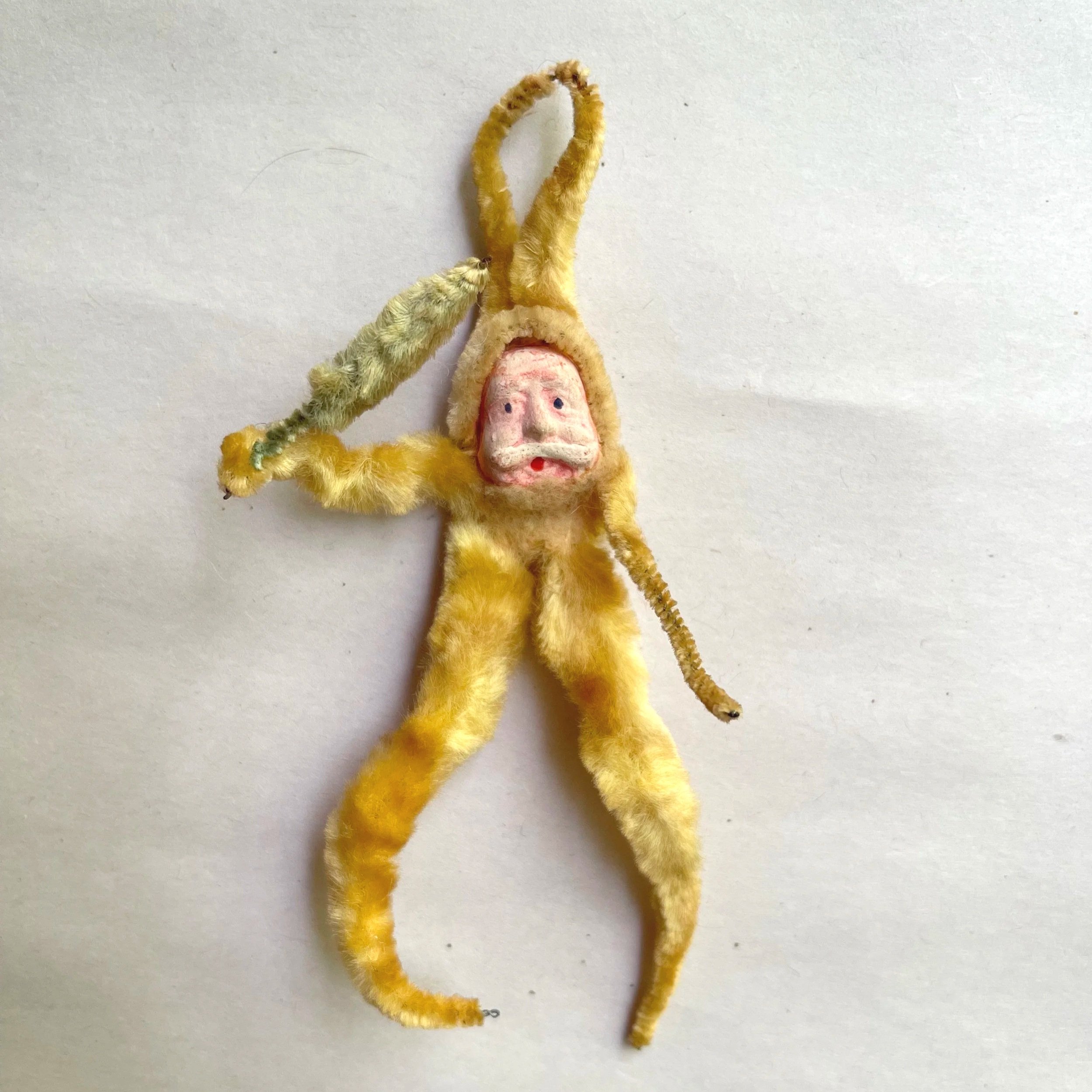 Vintage gold chenille Santa ornament with a hand-painted composition face and long curved legs.