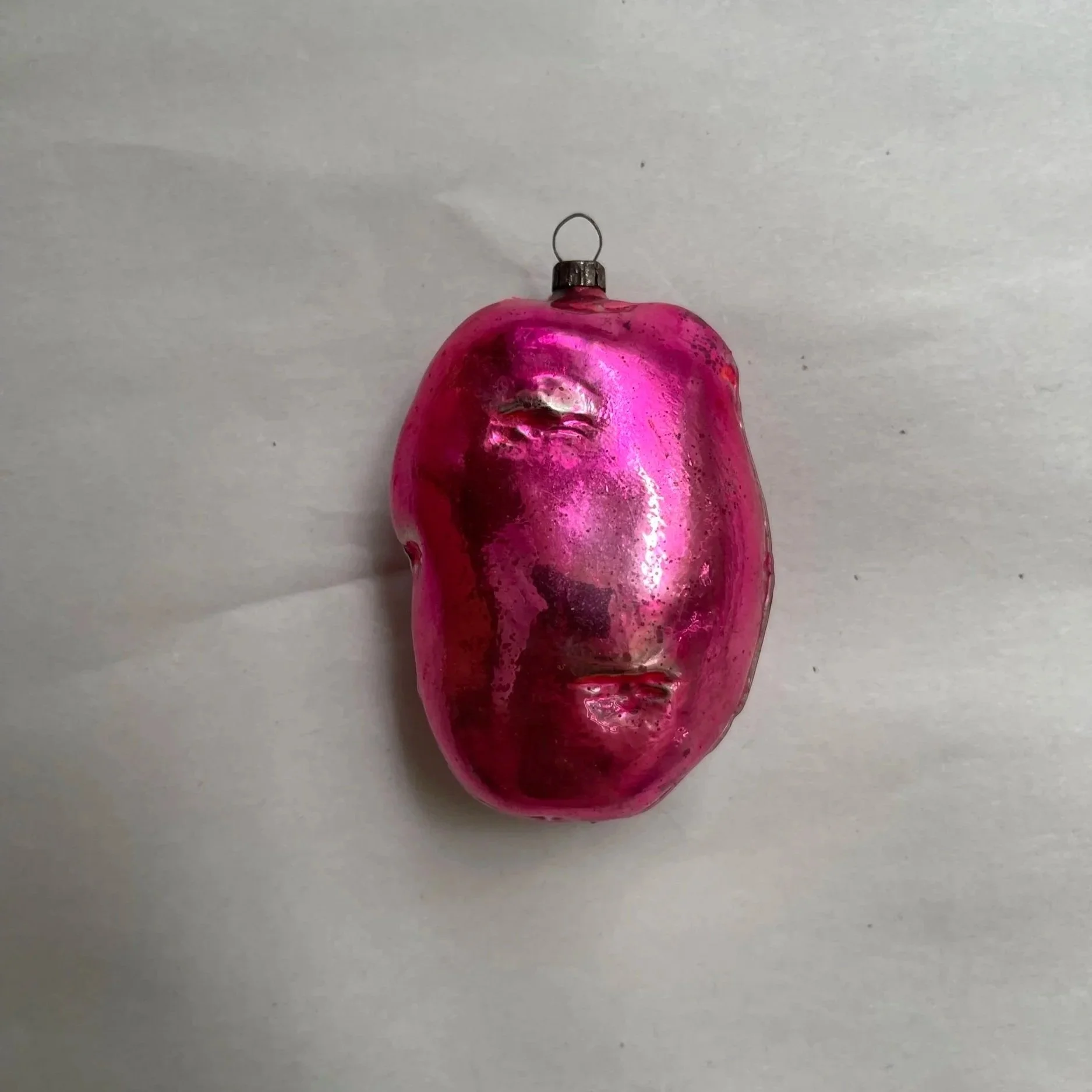 Antique German molded-glass potato Christmas ornament with a metallic pink finish.
