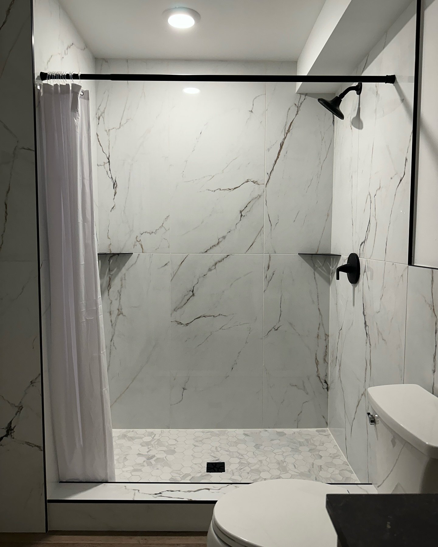 Latest bathroom remodel - part of an entire basement buildout! Large tiles minimize grout lines and accentuate the marble veining.