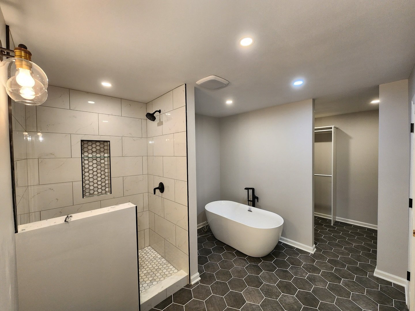 Custom modern bathroom complete with hexagon tile floor, shower &amp; niche. Seamless oversized tile in shower, free-standing tub with modern black fixtures and spacious walk-in closet. Just waiting on the glass door! 

Contact us today for a free es