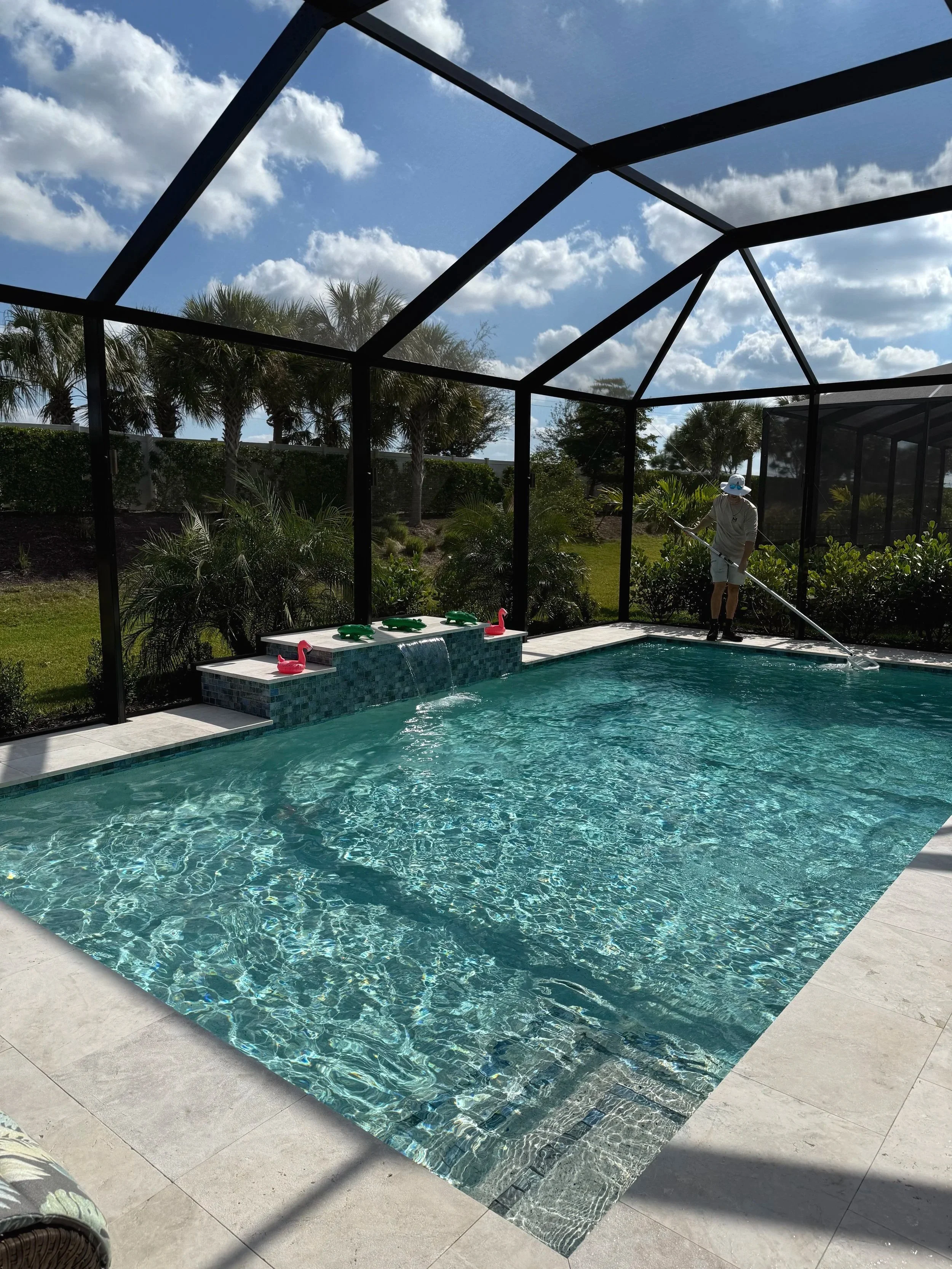 Two pool filters, one dirty and one clean, standing side by side on a pool deck overlooking a swimming pool.