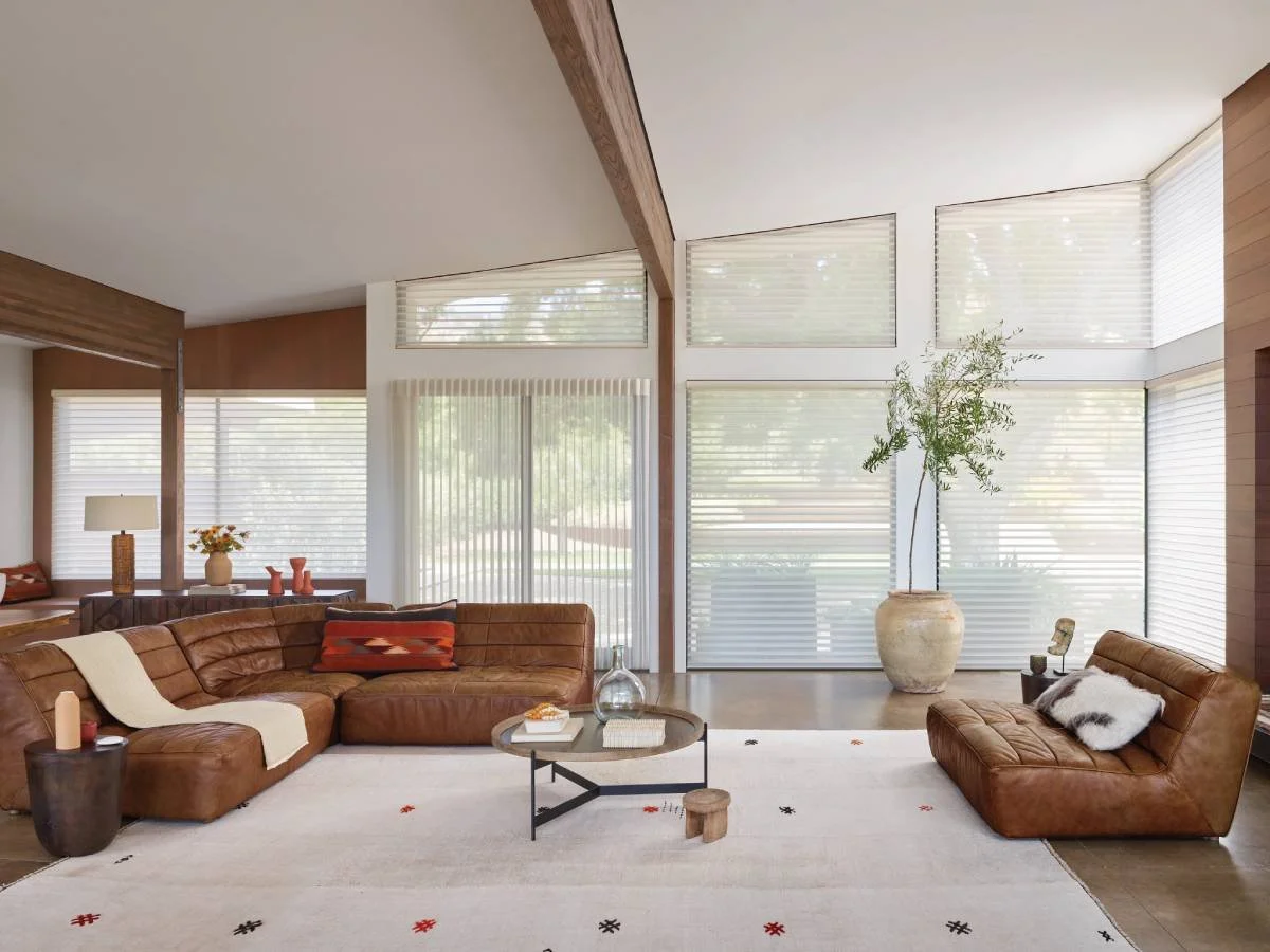 Motorized window shades covering multiple living room windows.
