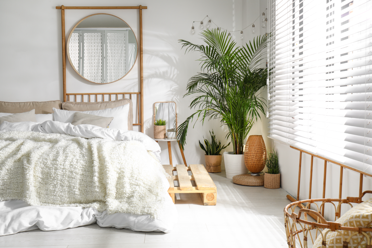Boho chic bedroom with eclectic decor and white window blinds.
