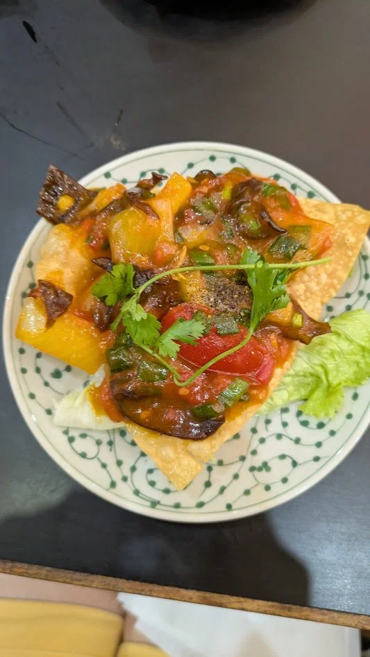 hoành thánh chiên is a signature, crispy appetizer from Hoi An, often described as "Vietnamese nachos." It features a deep-fried, crunchy wonton wrapper topped with a  mixture of minced pork, shrimp, spices, and a sweet-and-sour sauce made from stir-