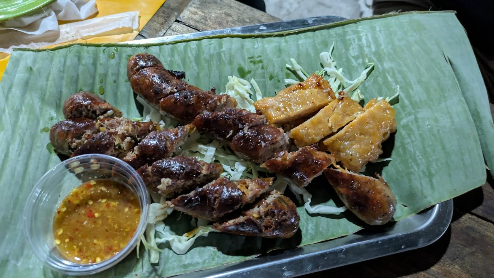 Sai Qua - Spicy herbal style Loatian pork sausage served on a banana leaf with spicy dipping sauce and sliced cabbage. This was another dish from the night market when we were on our food tour. Grady liked it a lot more than the fried silkworm!
