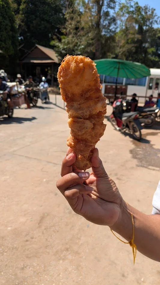 Num chek chien - a popular street food snack made by dipping flattened bananas into a crispy batter of rice flour, coconut milk, and sesame seeds, then deep-frying them. So yummy and so fattening!