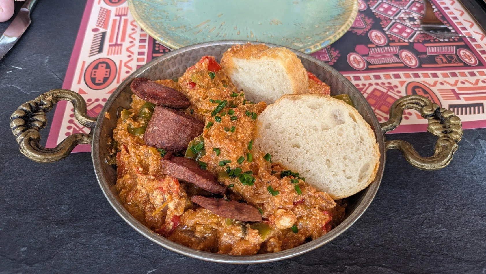 Fergesa - a traditional Albanian dish, specifically from the Tirana region, consisting of a mixture of roasted red peppers, tomatoes, onions, garlic, and feta cheese and baked in a clay pot. This particular dish was served with Albanian sausage. Grad