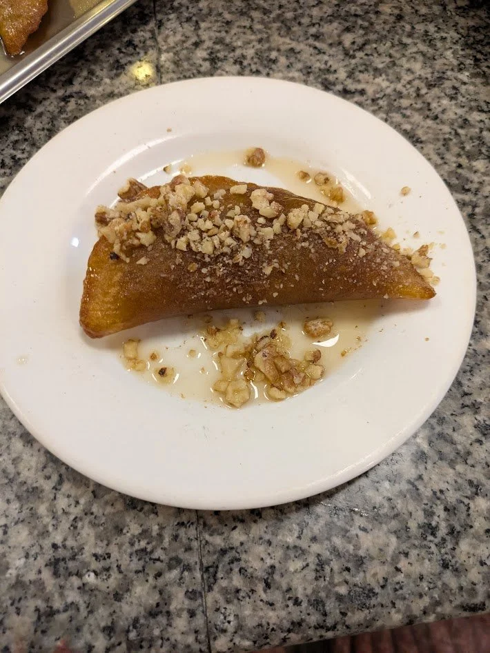 Kadaif - a pastry made of very thin, shredded phyllo-like dough. It is baked until crispy,  soaked in a sweet syrup, and filled with nuts. Very delicious! 