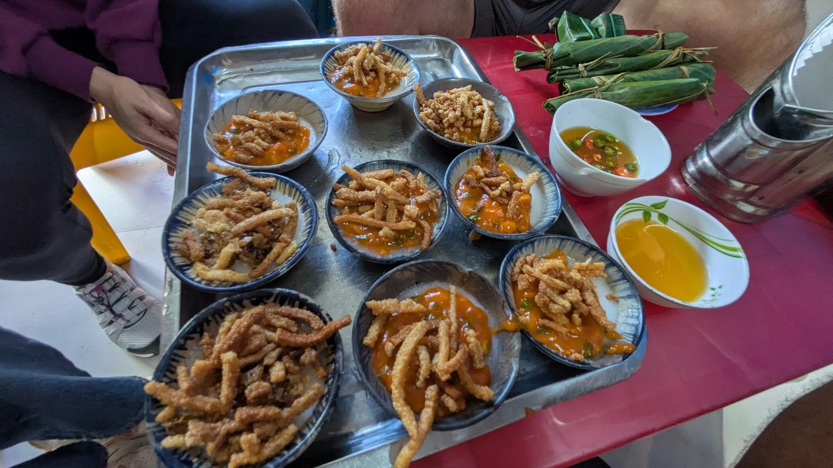 Bánh bèo are delicate, small Vietnamese steamed rice cakes, served as a popular snack with savory toppings like shrimp, crispy pork skin, scallion oil, and a sweet-savory dipping sauce. The cakes are made from rice flour, steamed in small ceramic dis
