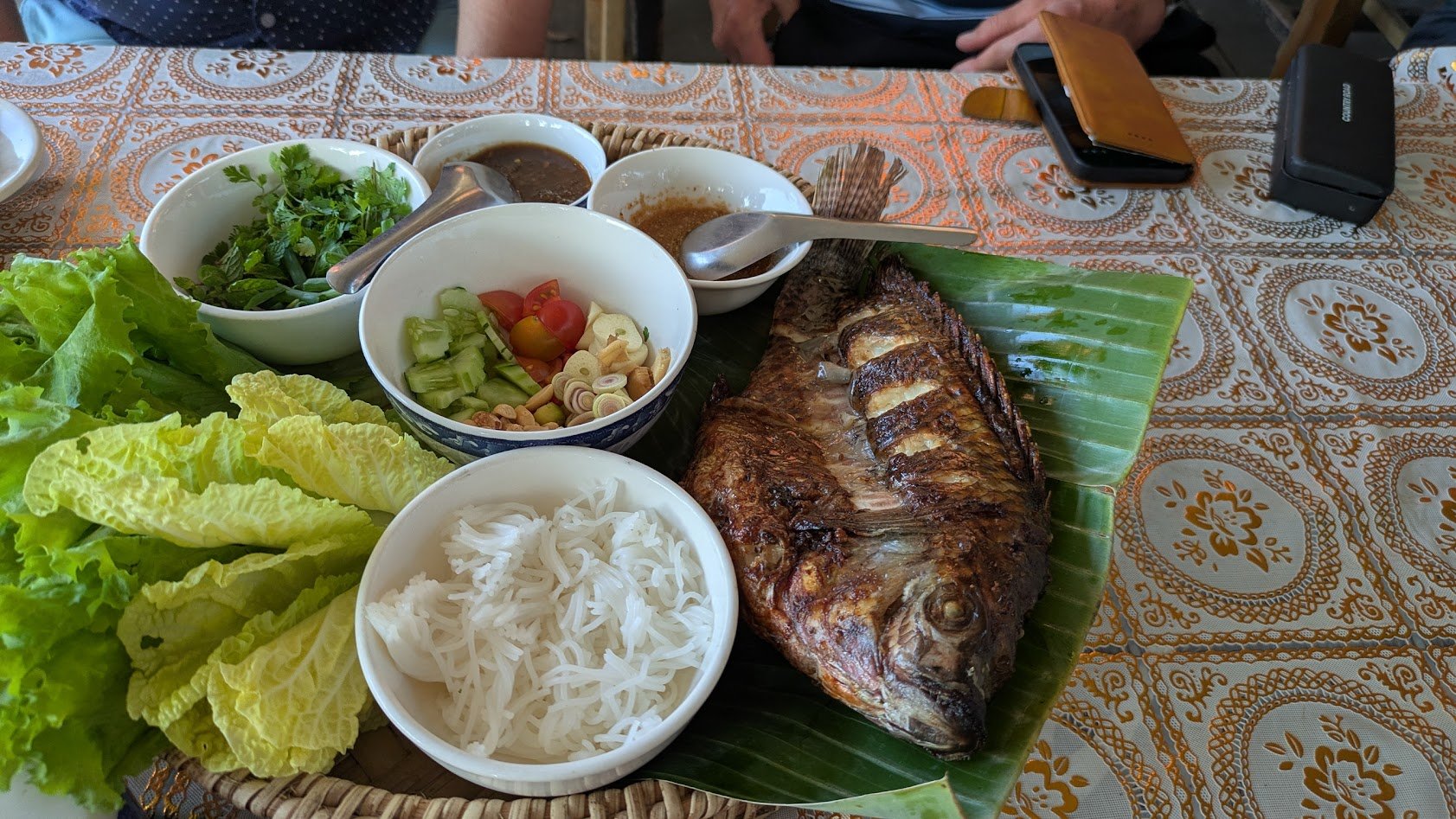 Fish Pun Bah - A crispy fried whole fish—often pompano, tilapia, or snapper—served with fresh herbs, rice noodles, vegetables, and dipping sauces that you wrap in lettuce leaves. It is a highly social meal shared among diners. It was seriously delici