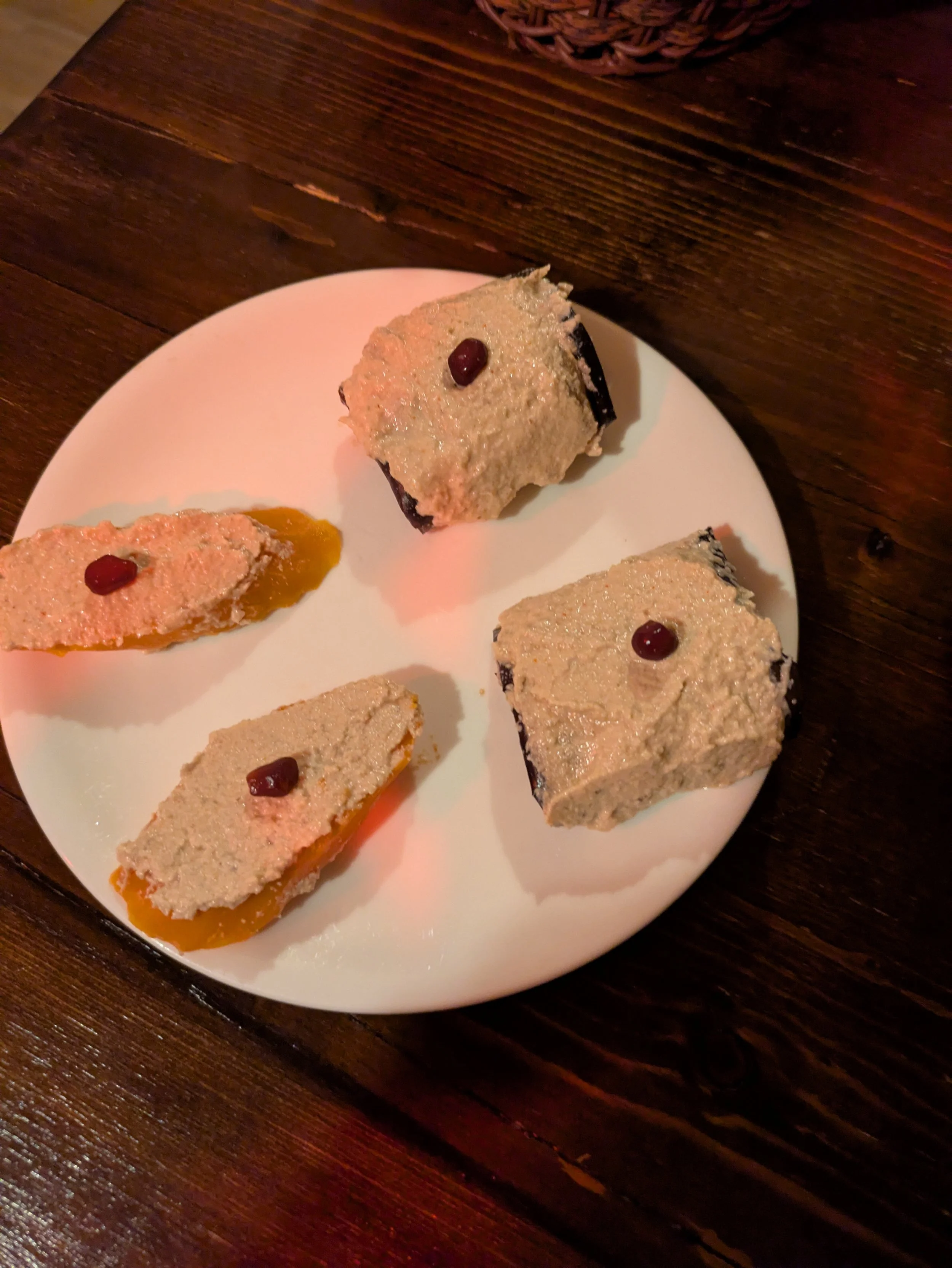Badrijani Nigvzit - Grilled eggplant slices spread with a rich paste of ground walnuts, garlic, herbs, spices, and garnished with fresh pomegranate seeds. It was really good.