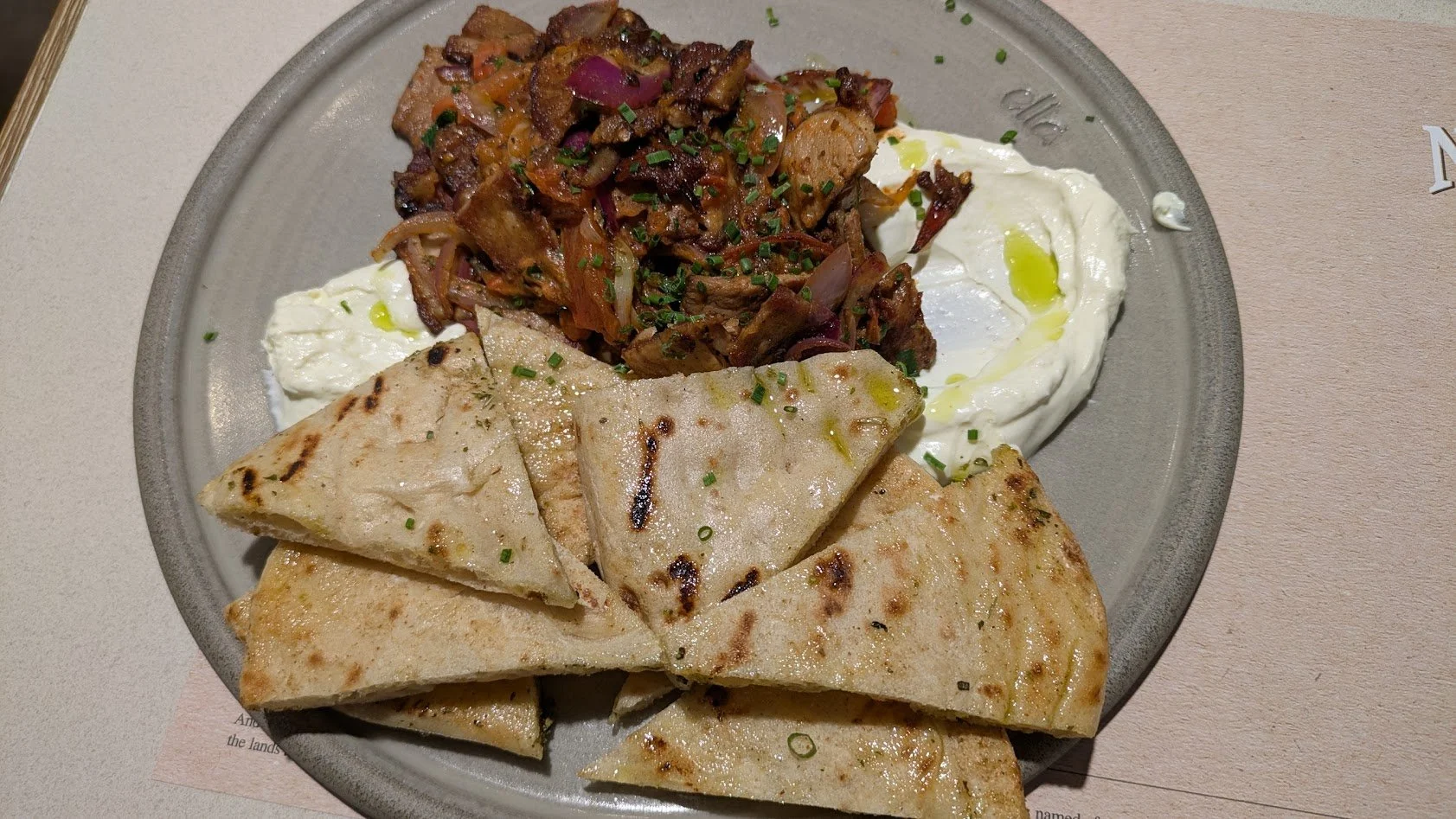 Gyro - of course! Seasoned meat—typically pork or chicken (not lamb like we assume in the US). It is roasted on a vertical rotisserie, sliced, and served with grilled, oil-brushed pita bread and tzatziki (yogurt-cucumber sauce) on the side. Of course