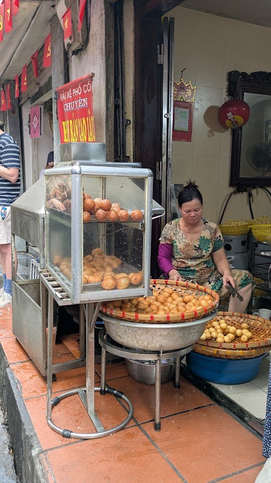 Banh ran is a Vietnamese deep-fried glutinous rice ball originating from Northern Vietnam, often called a "Vietnamese donut". It consists of a crispy, golden-brown shell—often coated in sesame seeds—and typically comes in two varieties: a sweet versi