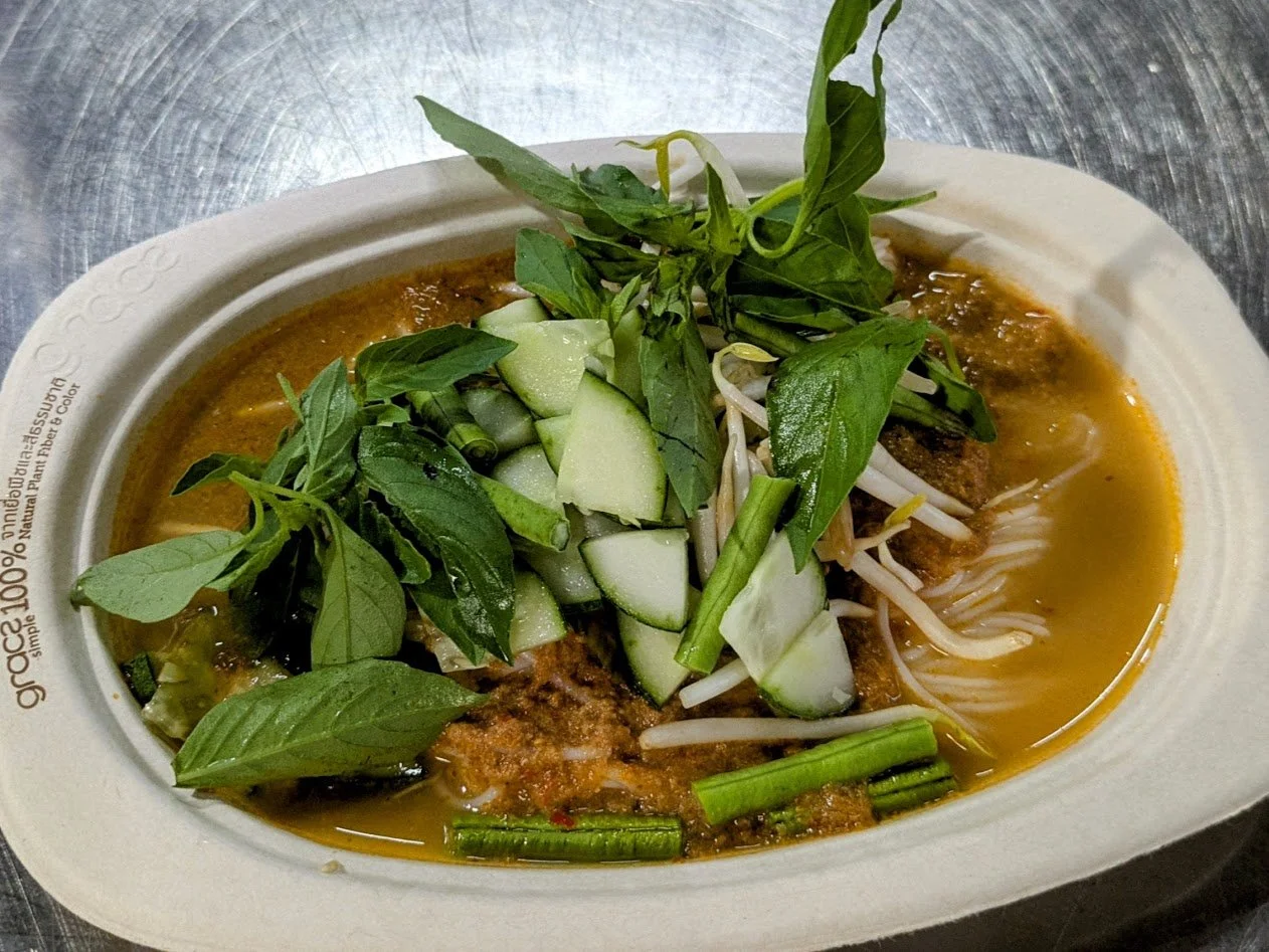 Khanom Jeen Nam Ya - Thai fermented rice noodles with fish curry. It features fresh, thin, slightly fermented rice noodles topped with a fish-based curry sauce and served with a variety of fresh vegetables and herbs. 