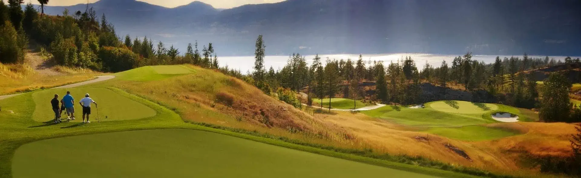 Ridge Course at Predator Ridge Golf Resort with golfers walking fairway overlooking Okanagan Lake and rolling hills