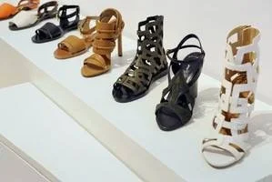 Strappy heeled sandals displayed on a white pedestal inside the Maiyet store