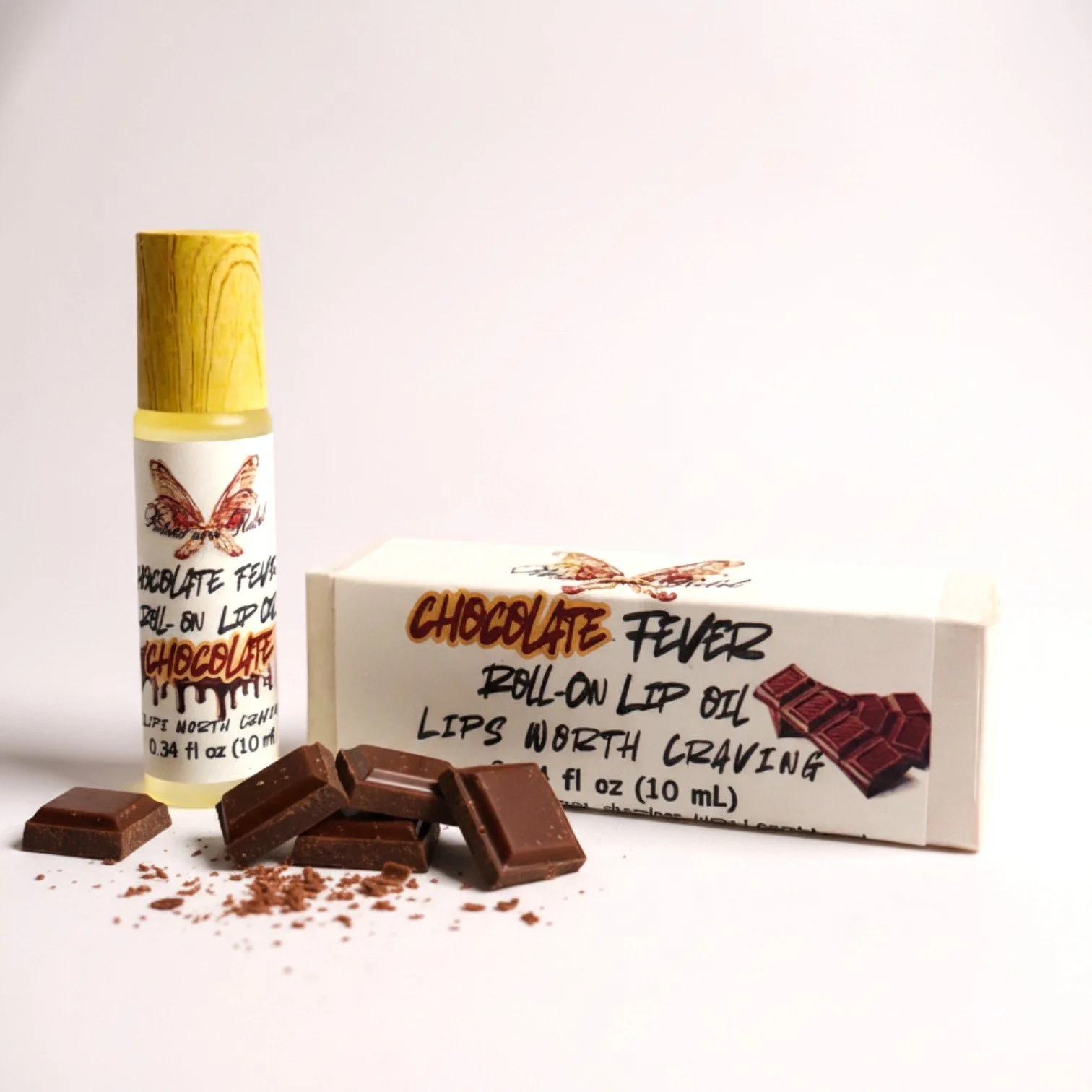 Chocolate Fever roll on lip oil, product box, pieces of chocolate, ritual and rebel.jpg