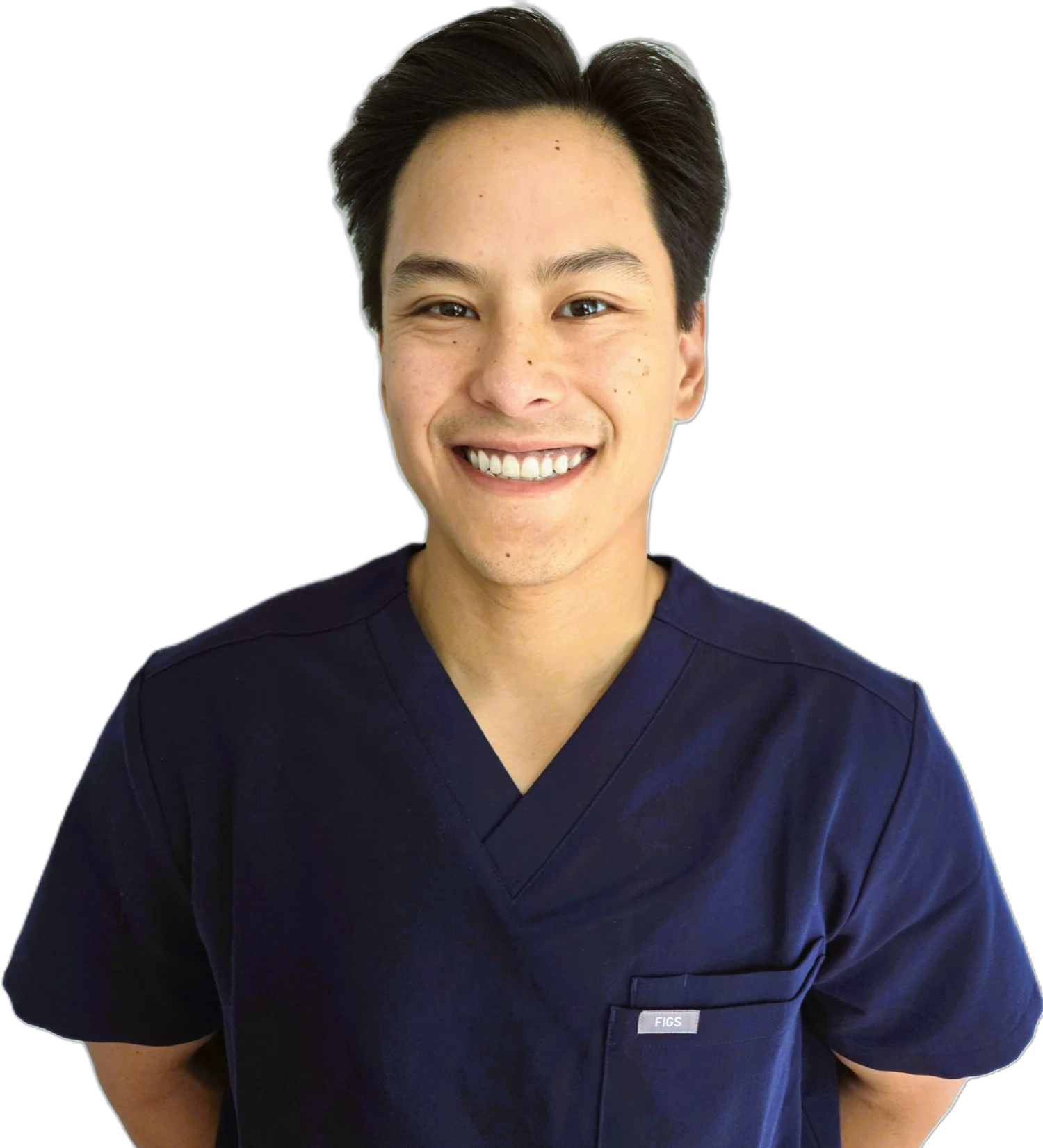 A man with dark hair in dental scrubs smiling at the camera.