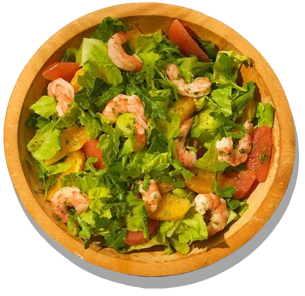 Arugula and shrimp salad in a wooden bowl.