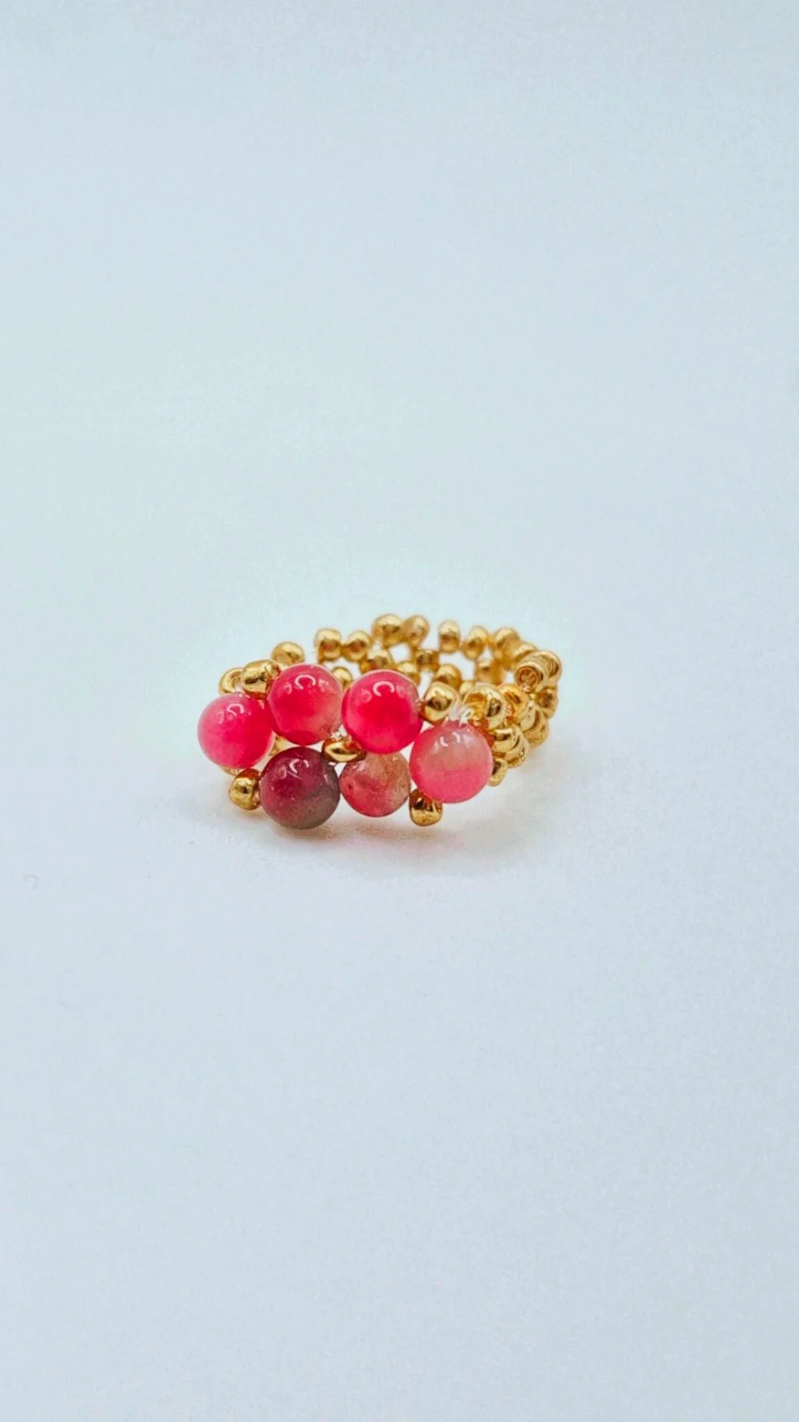 a one-size beaded ring with pink carnelia and gold metal beads