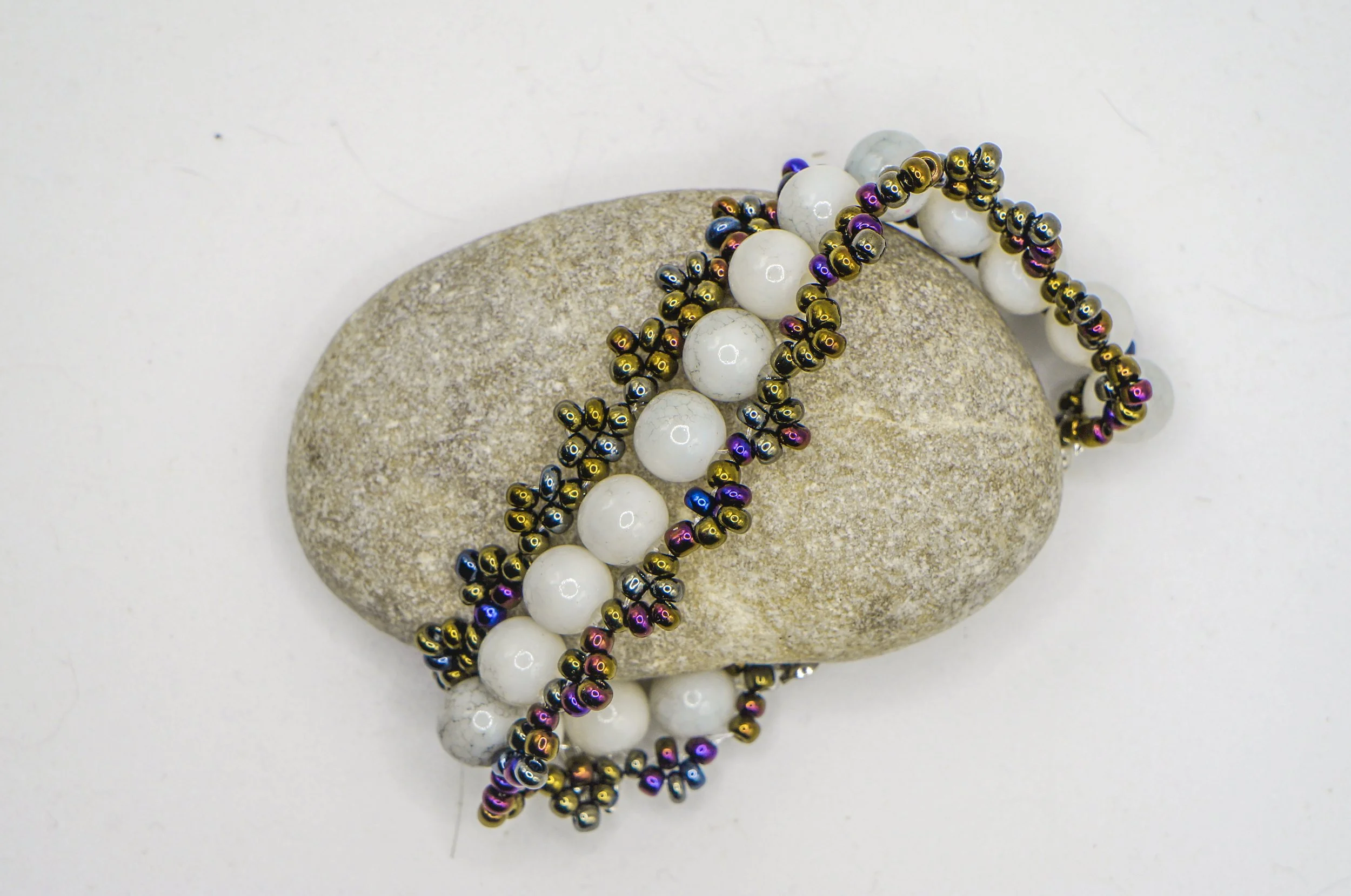a beaded bangle using white marble beads and color-changing black metallic seed beads
