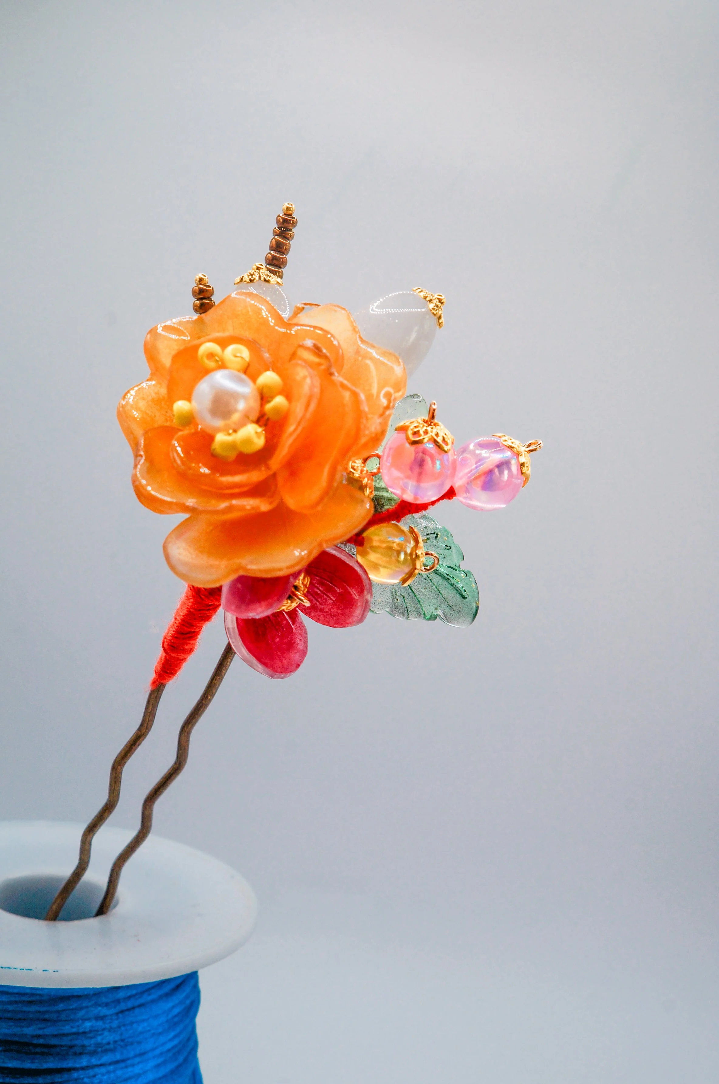 hand made Chinese hair pin using long wavy U-pin, featuring an orange mudan flower, acrylic and glass beads