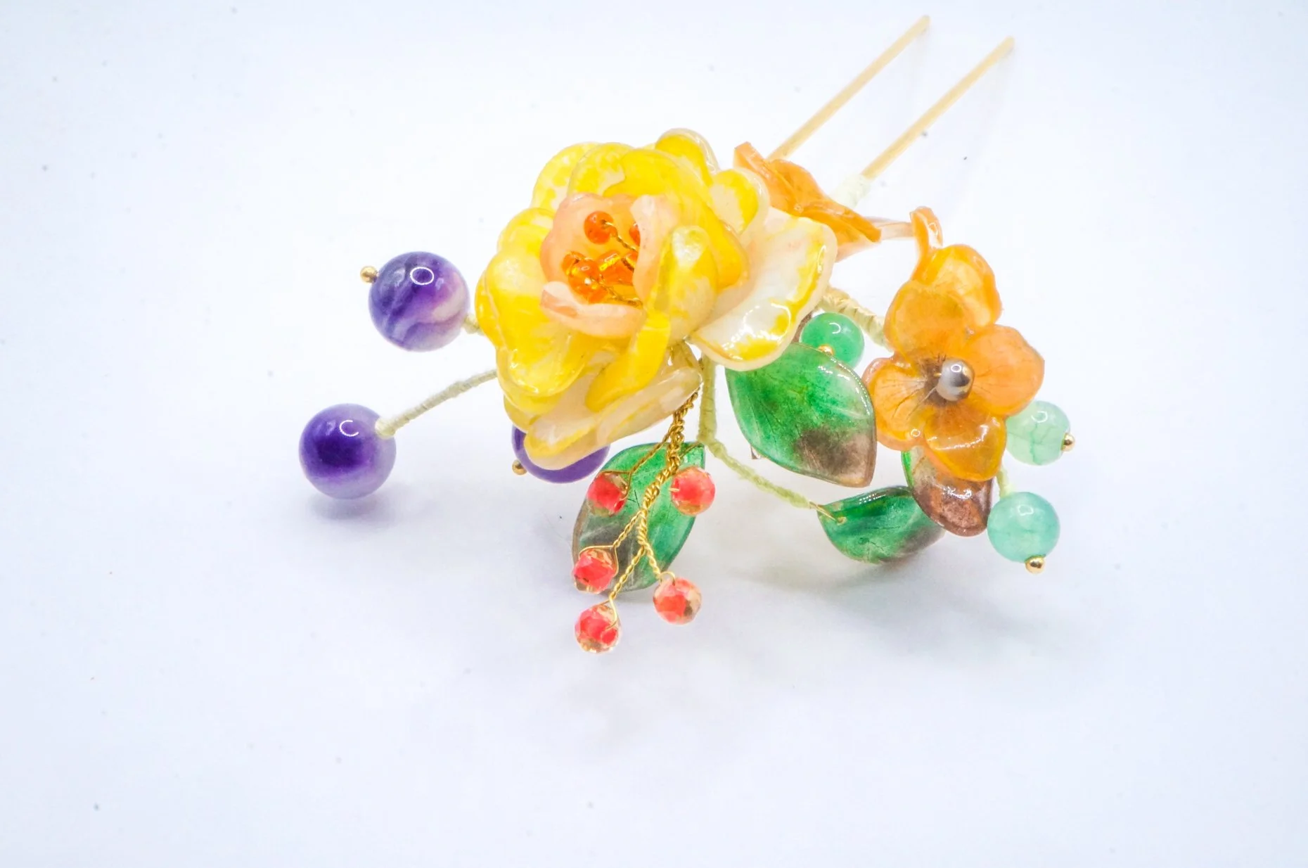 closeup of a handmade Chinese hairstick with yellow rose, butterfly milkweed, and various beads