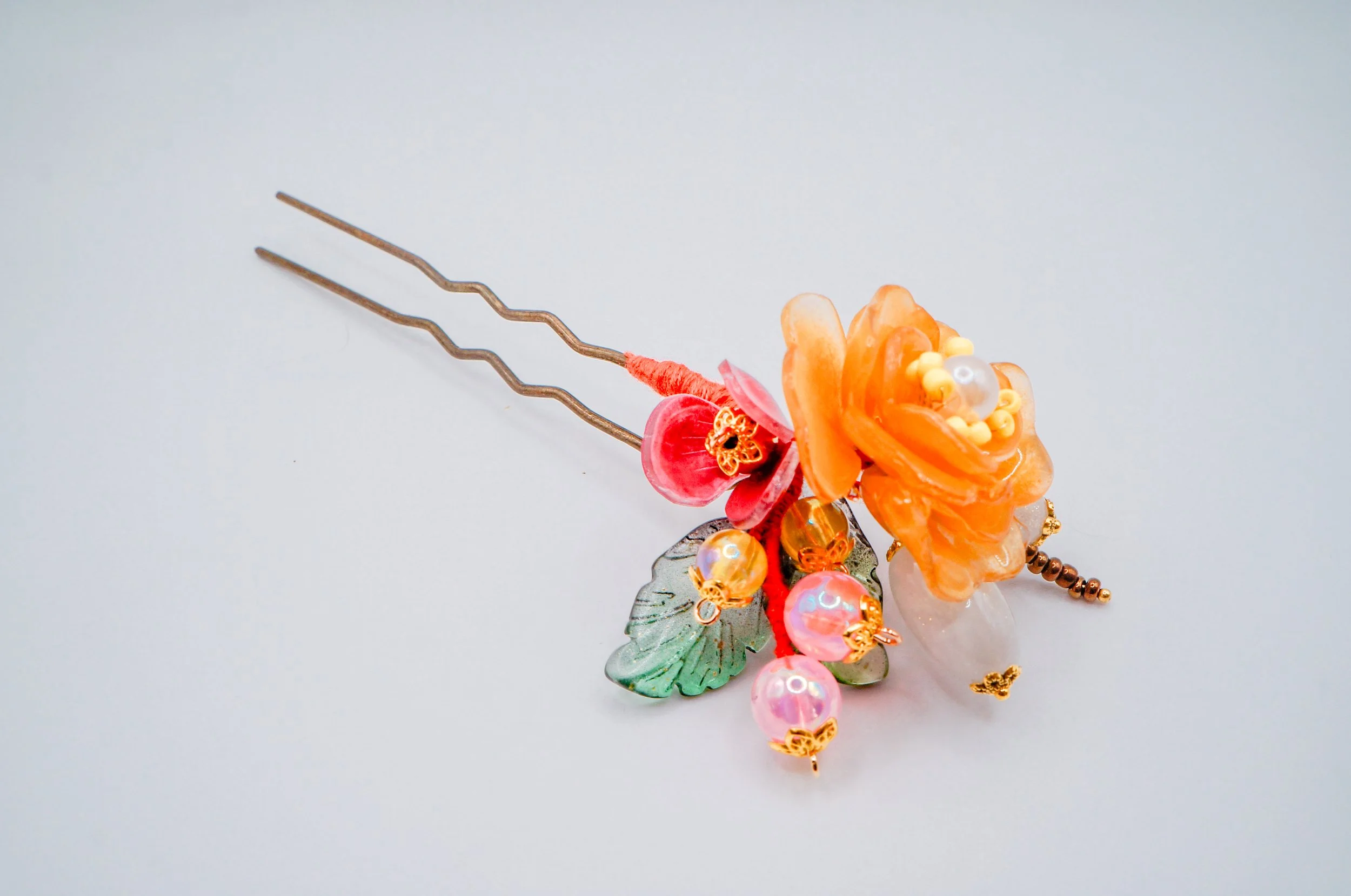 hand made Chinese hair pin using long wavy U-pin, featuring an orange mudan flower, acrylic and glass leaf beads