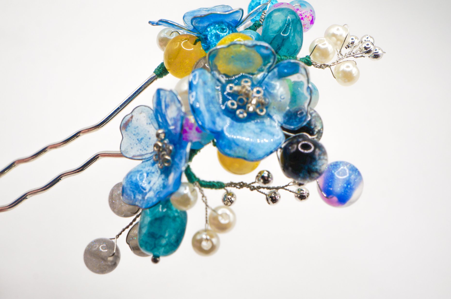 closeup of a blue mica powder dipped handmade chinese hairstick with various gemstone and glass beads