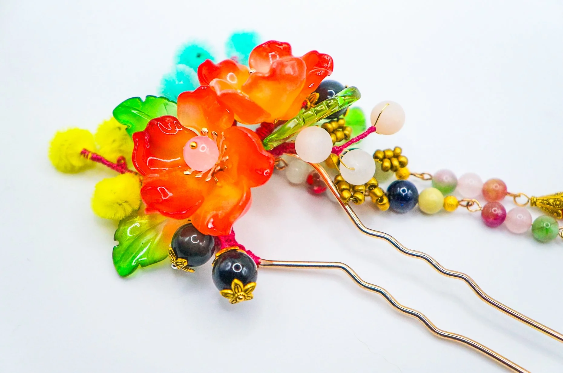 Handmade Chinese hairstick for medium hair on a gold French stick base with wavy design in the center for a stronger hold, with red glass petals, glass leaves, silkflower accents and mixed beads.