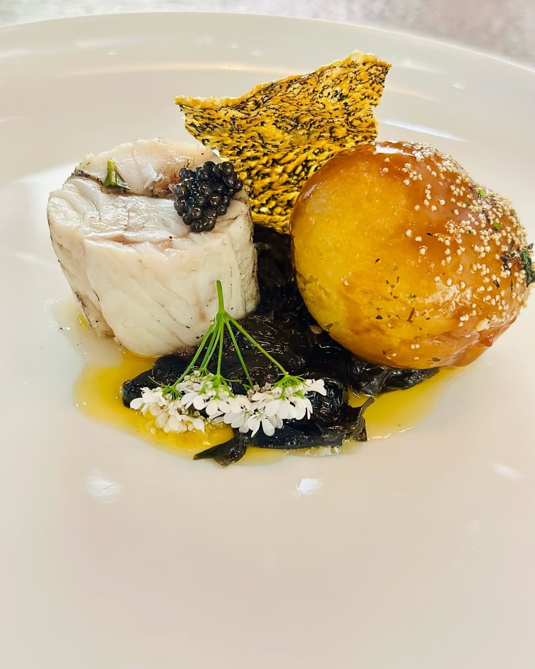 Perspective Dining's Noisette of grouper, com donut, trout butter dressing, cured pig cheek lardons, ginger stem, seaweed, caviar.