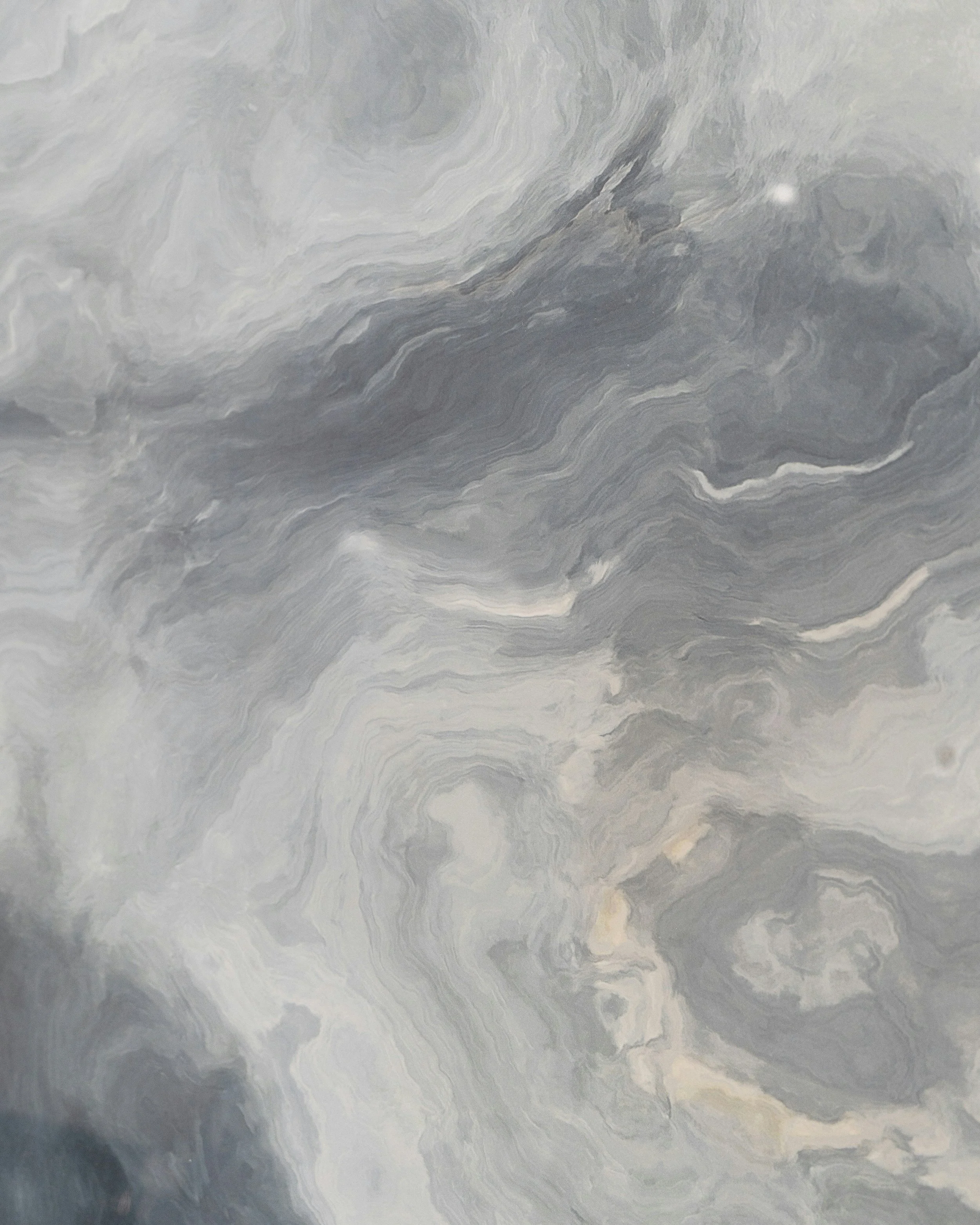 Close-up of a gray and white marble surface with swirling patterns and natural veining.