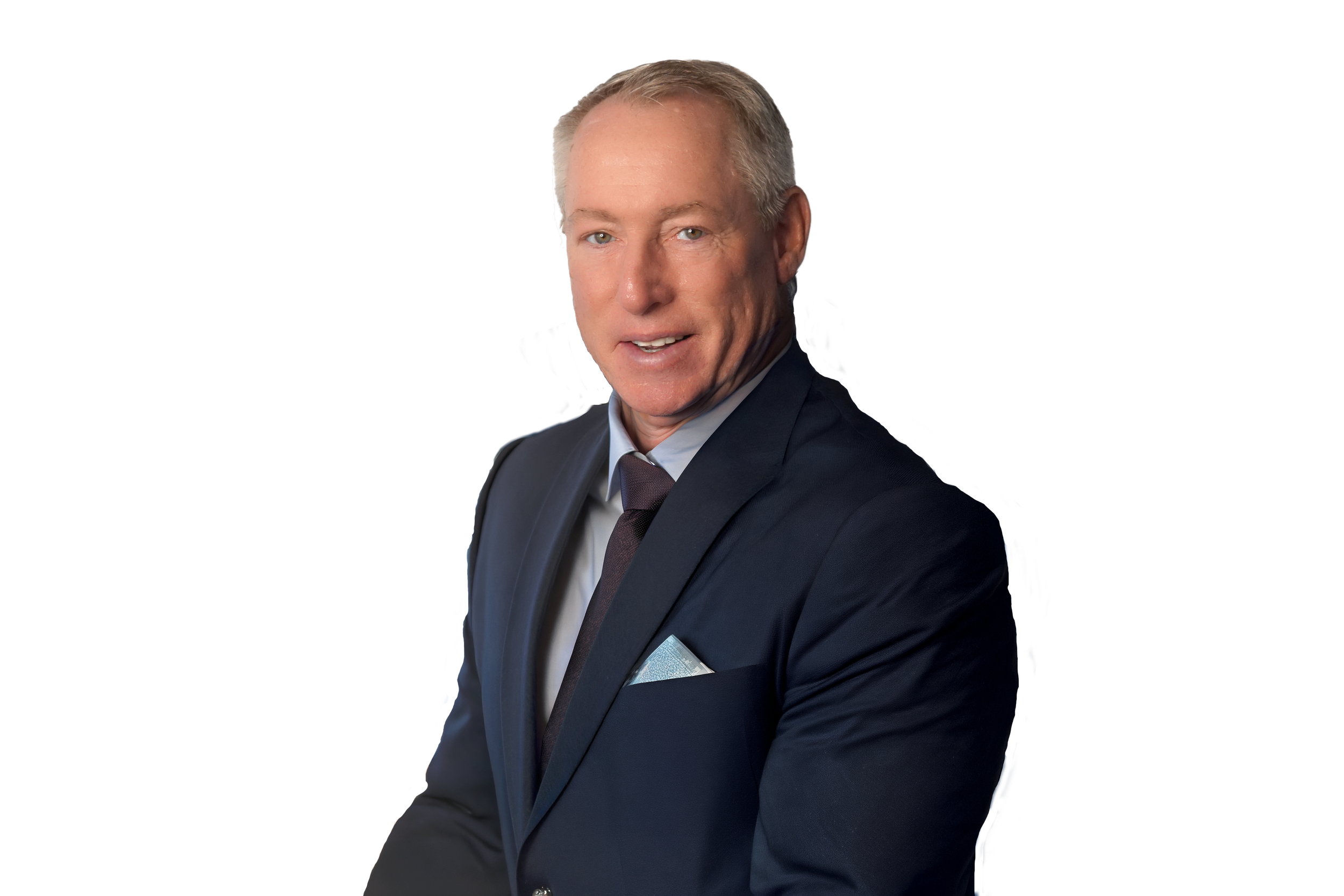 A smiling man with blonde hair wearing a navy suit jacket with a gray shirt on a white background