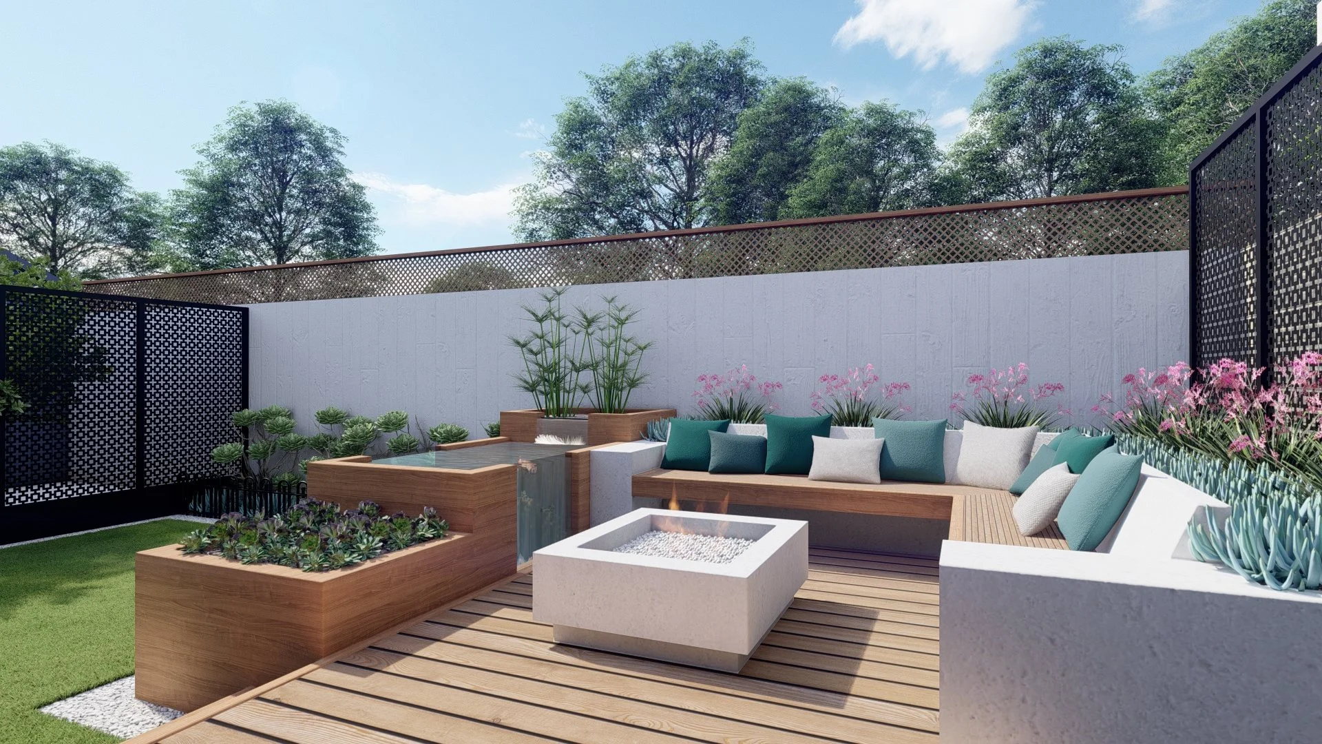A modern outdoor patio with wooden decking, a built-in L-shaped white concrete bench with teal and white cushions, a geometric fire pit, a raised wooden planter with succulents, and a small fountain. Pink flowers and various plants surround the seati