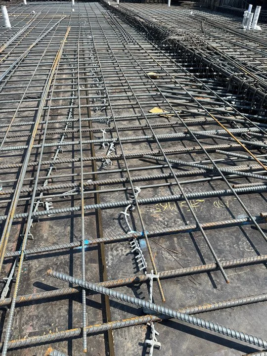 Close-up view of rebar and steel reinforcement bars arranged on a construction site for concrete work.