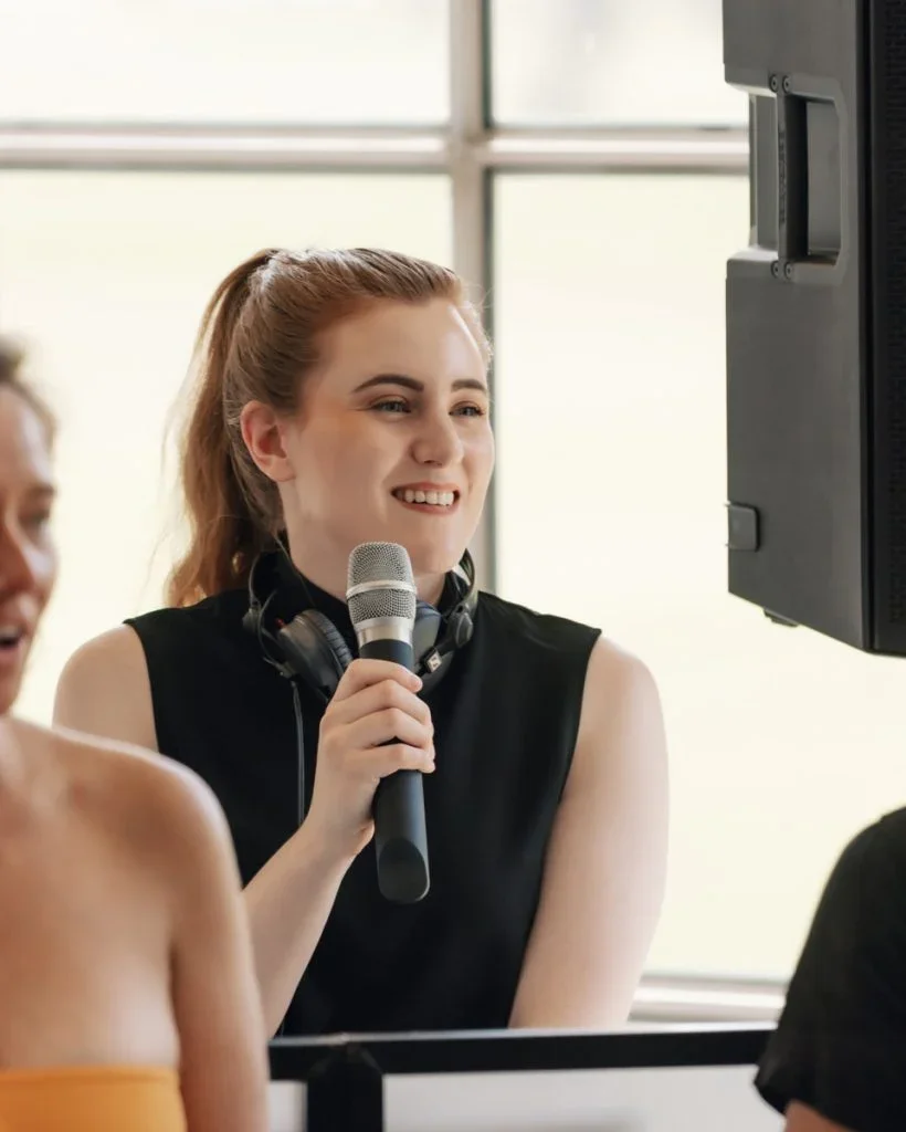 Melbourne DJ and MC using the microphone behind the speakers.webp