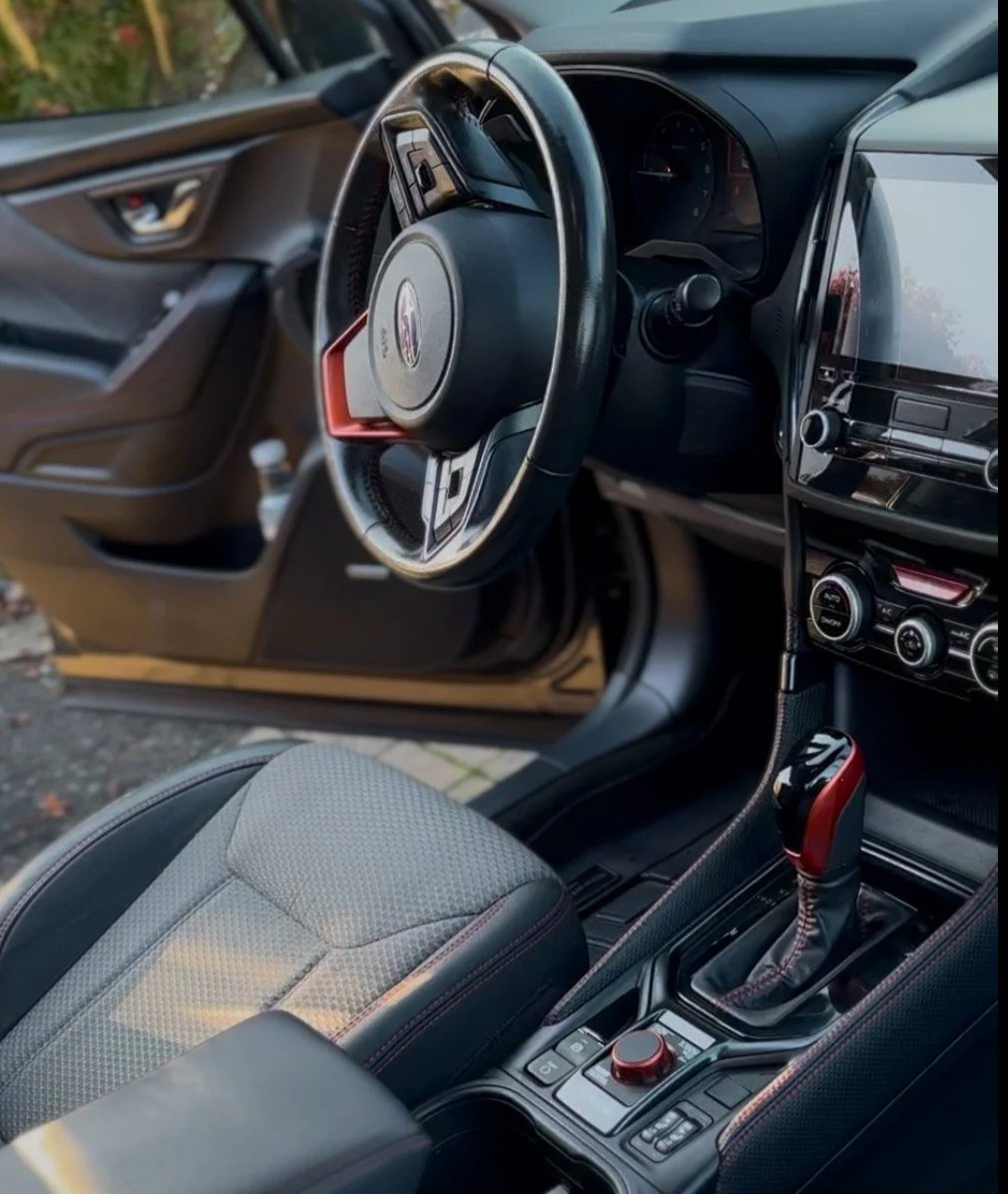 Interior of a modern car showing the steering wheel, dashboard, gear shift, and center console.