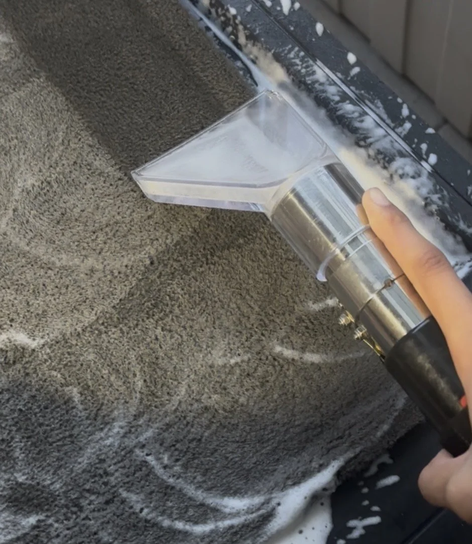Person using a paint sprayer to apply spray foam insulation to a ceiling wall.