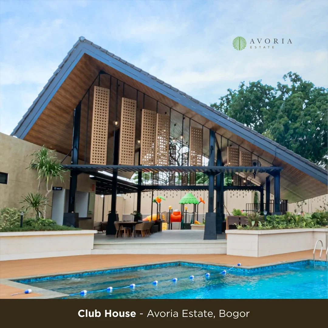 A modern club house with an open-air design, featuring a large sloped roof, wooden accents, and a surrounding pool area with lounge chairs and a children's play area with colorful equipment, at Avoria Estate in Bogor.
