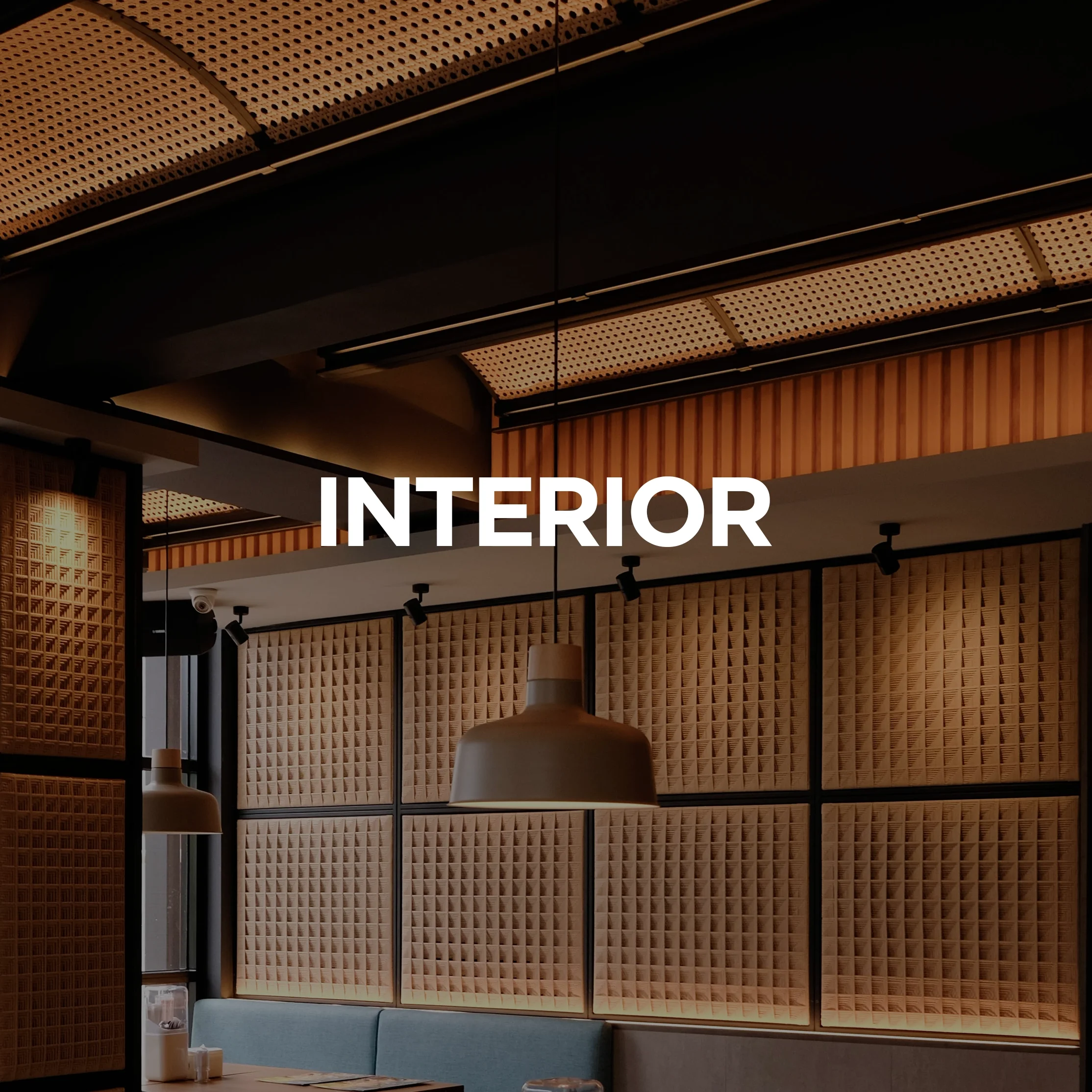 Interior of a modern restaurant or cafe with wooden wall panels, pendant lamp, and seating area.