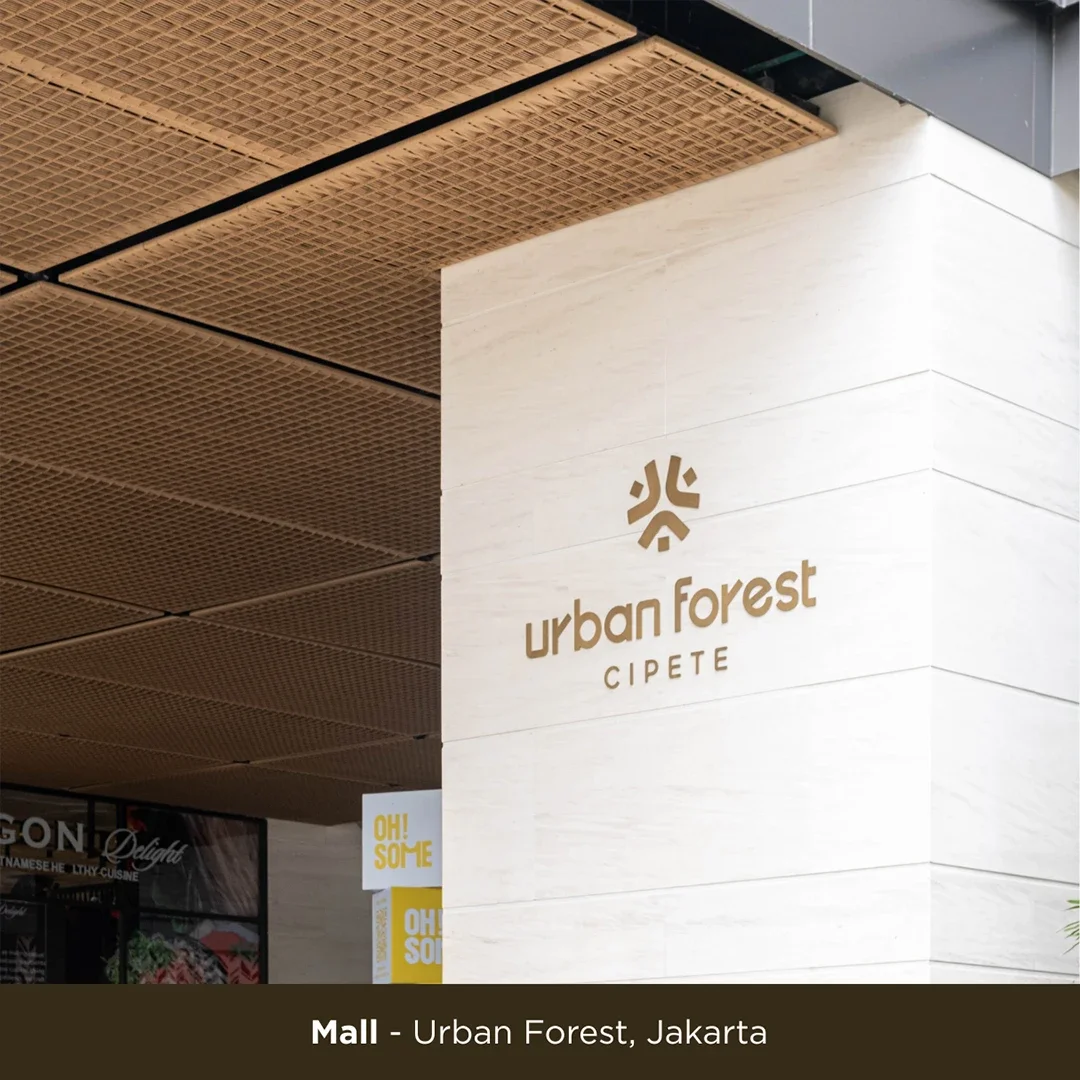 Sign for Urban Forest Cipete at a mall in Jakarta, with a logo above the text on a light-colored wall