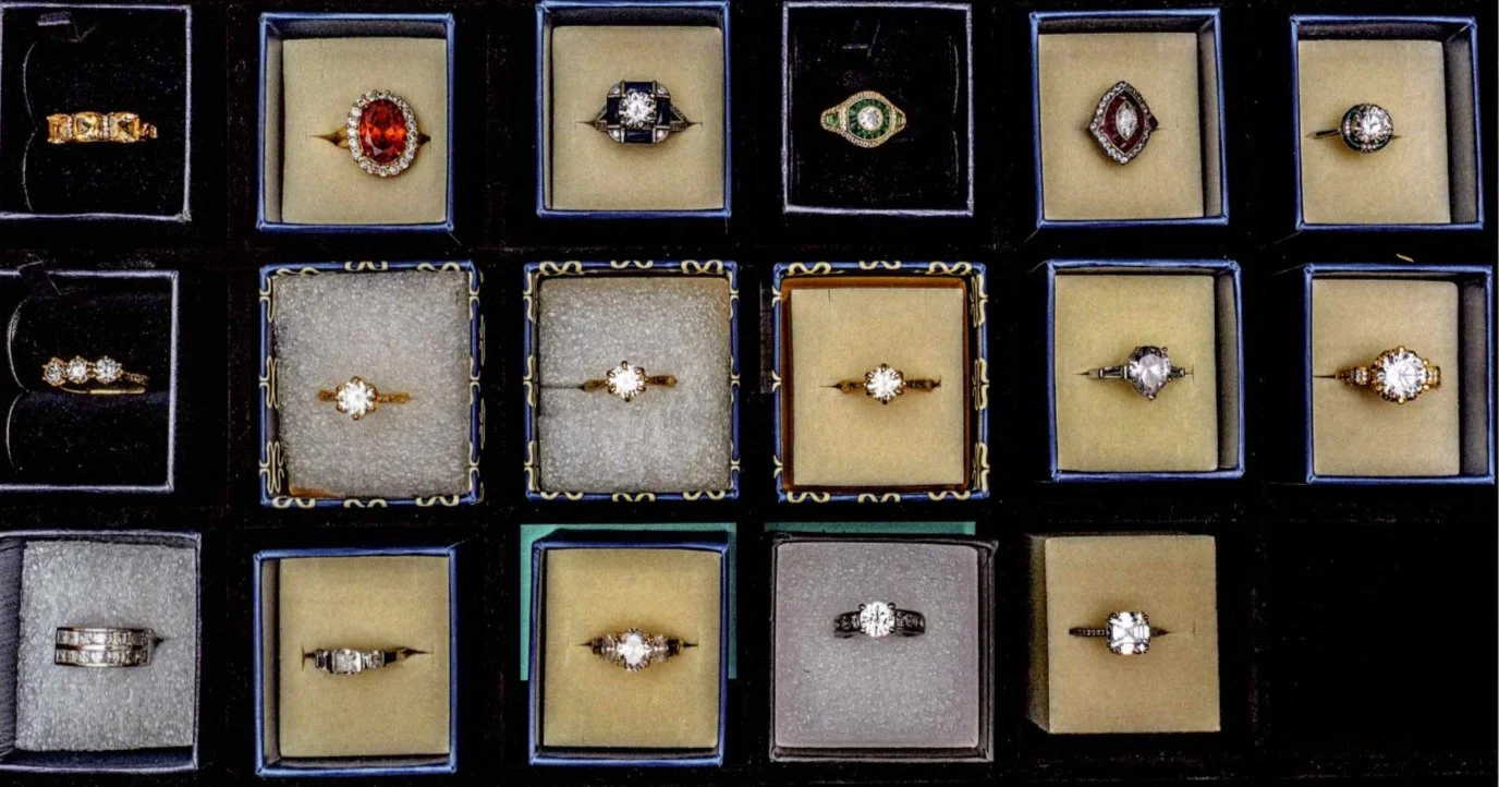 Collection of various rings, including diamond and gemstone rings, displayed in jewelry boxes.