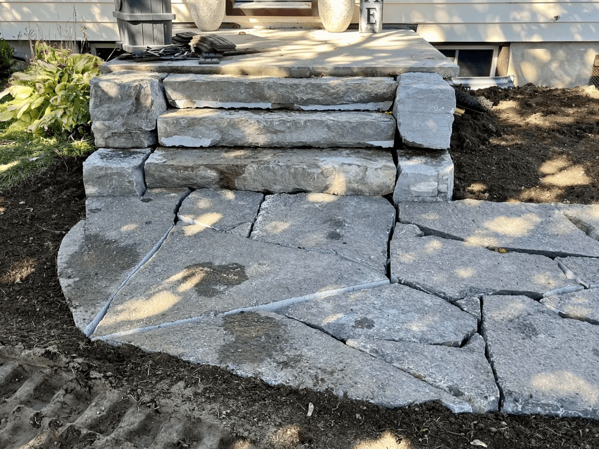 Stone steps and pathway made from large uneven rocks and concrete slabs, constructed in Kawartha Lakes by SMG Excavating.