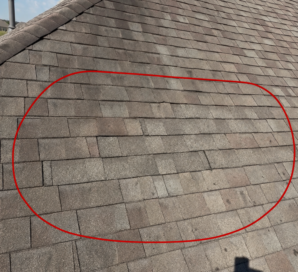 Completed asphalt shingle roof repair by Apex Roofing Solutions, with the repaired section outlined in red.