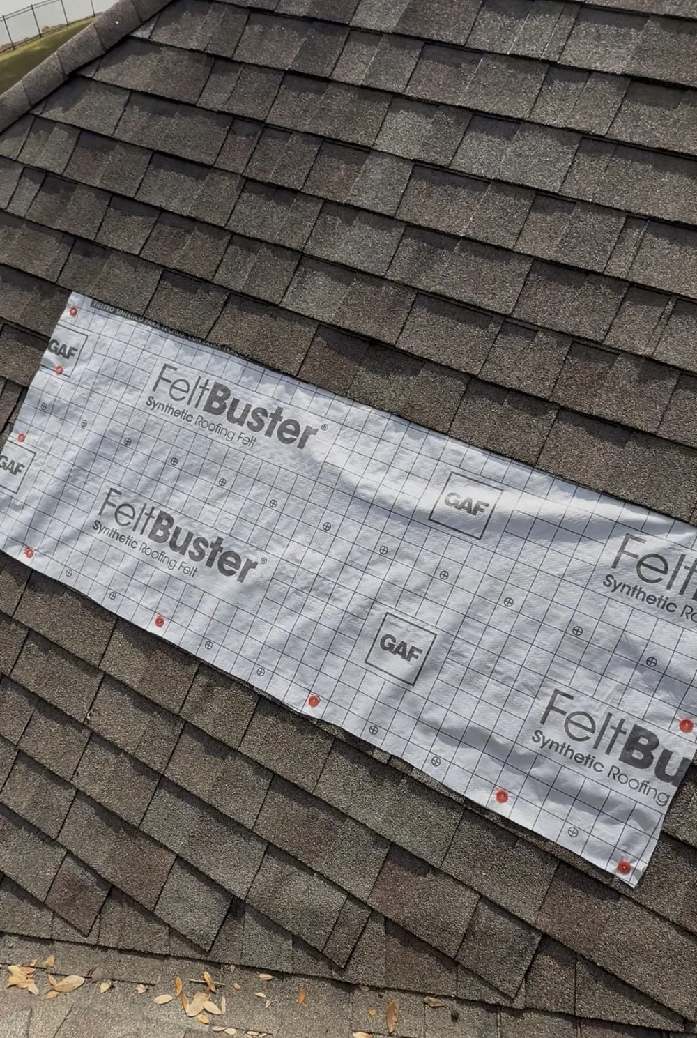 Temporary emergency roof covering secured over damaged shingles before permanent roof leak repair.