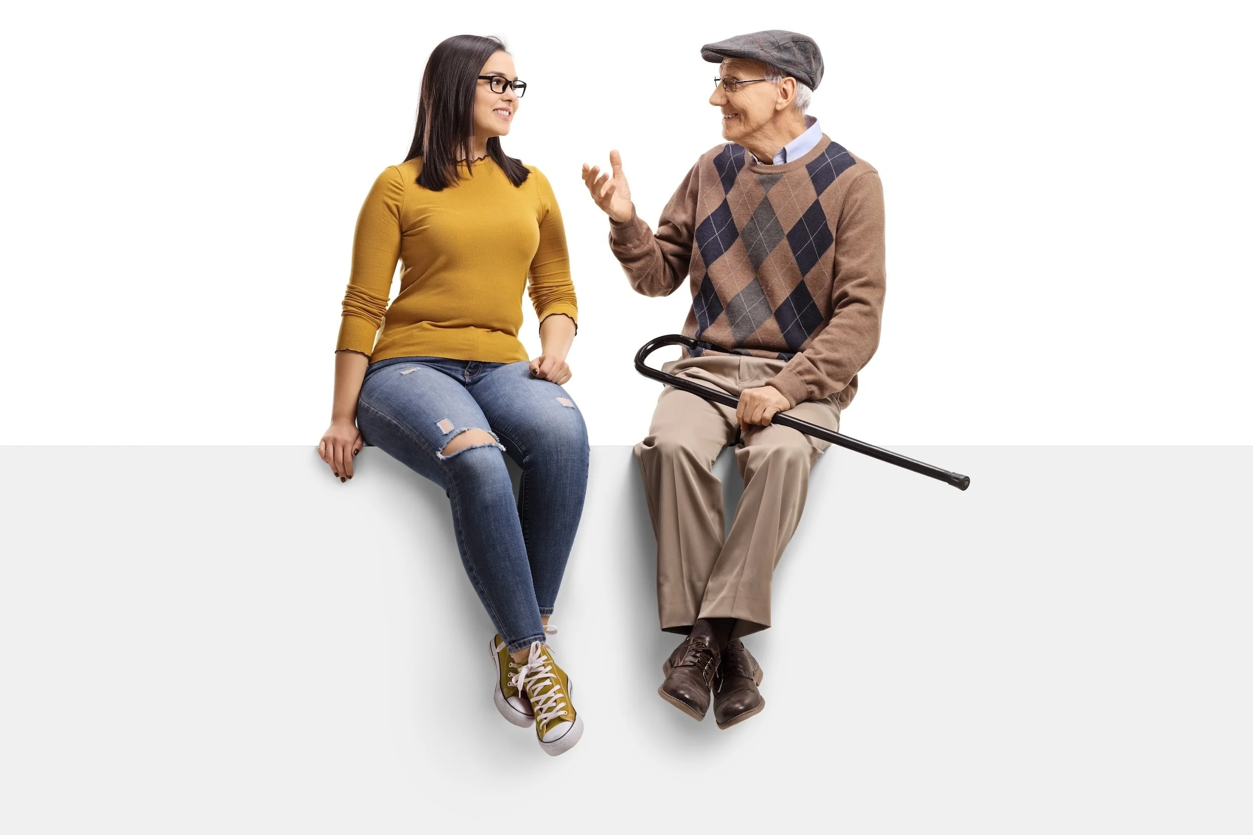 Symbolbild für 24-Stunden-Betreuung: Eine junge Frau und ein älterer Mann sitzen nebeneinander, sprechen miteinander und lächeln.