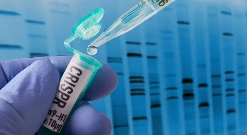 A gloved hand holding a CRISPR-Cas9 vial with a pipette, against a DNA gel electrophoresis background