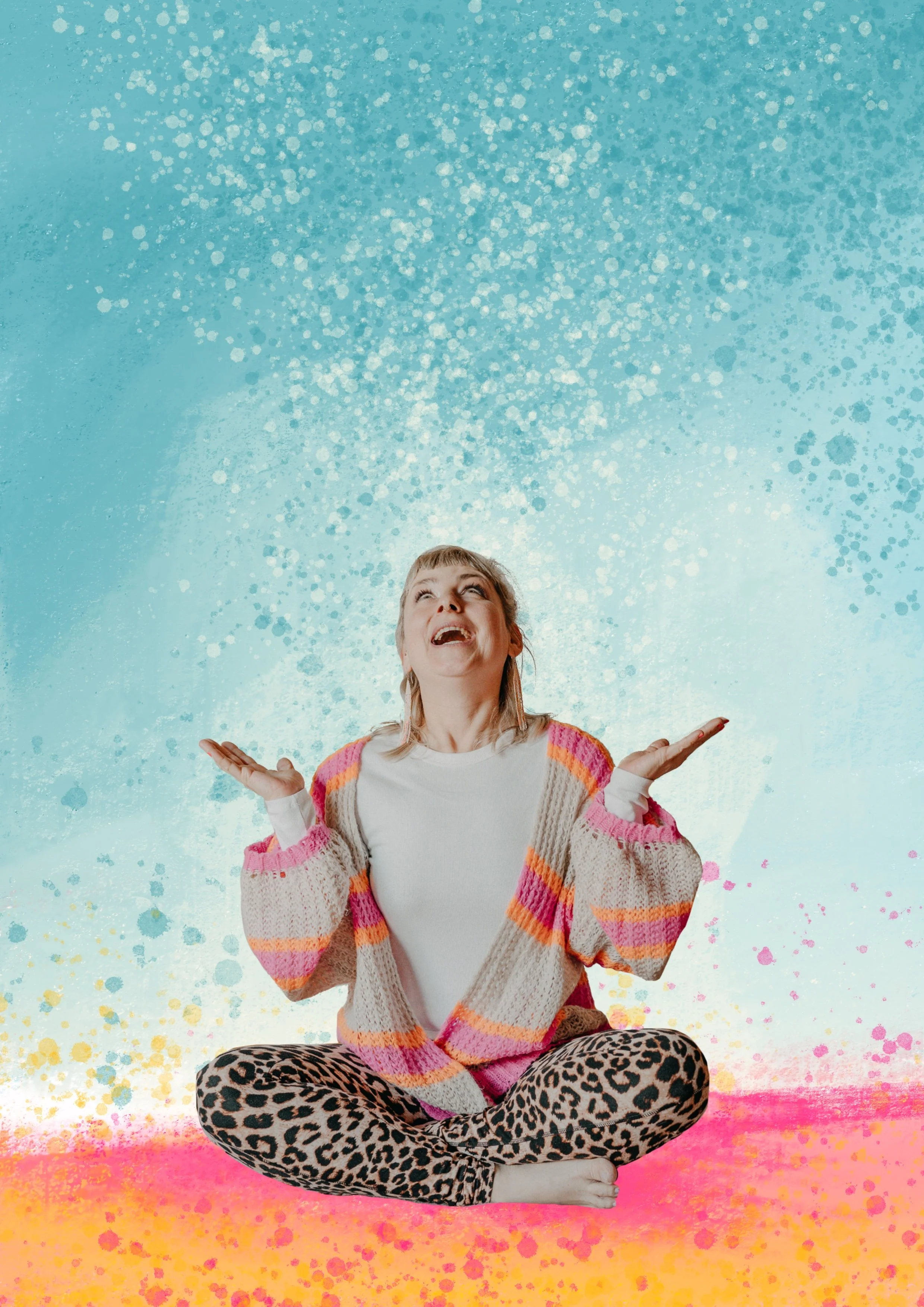 Junge Frau sitzt im Schneidersitz vor einem bunten, spritzigen Hintergrund, die Hände nach oben gestreckt, lächelnd und nach oben blickend.