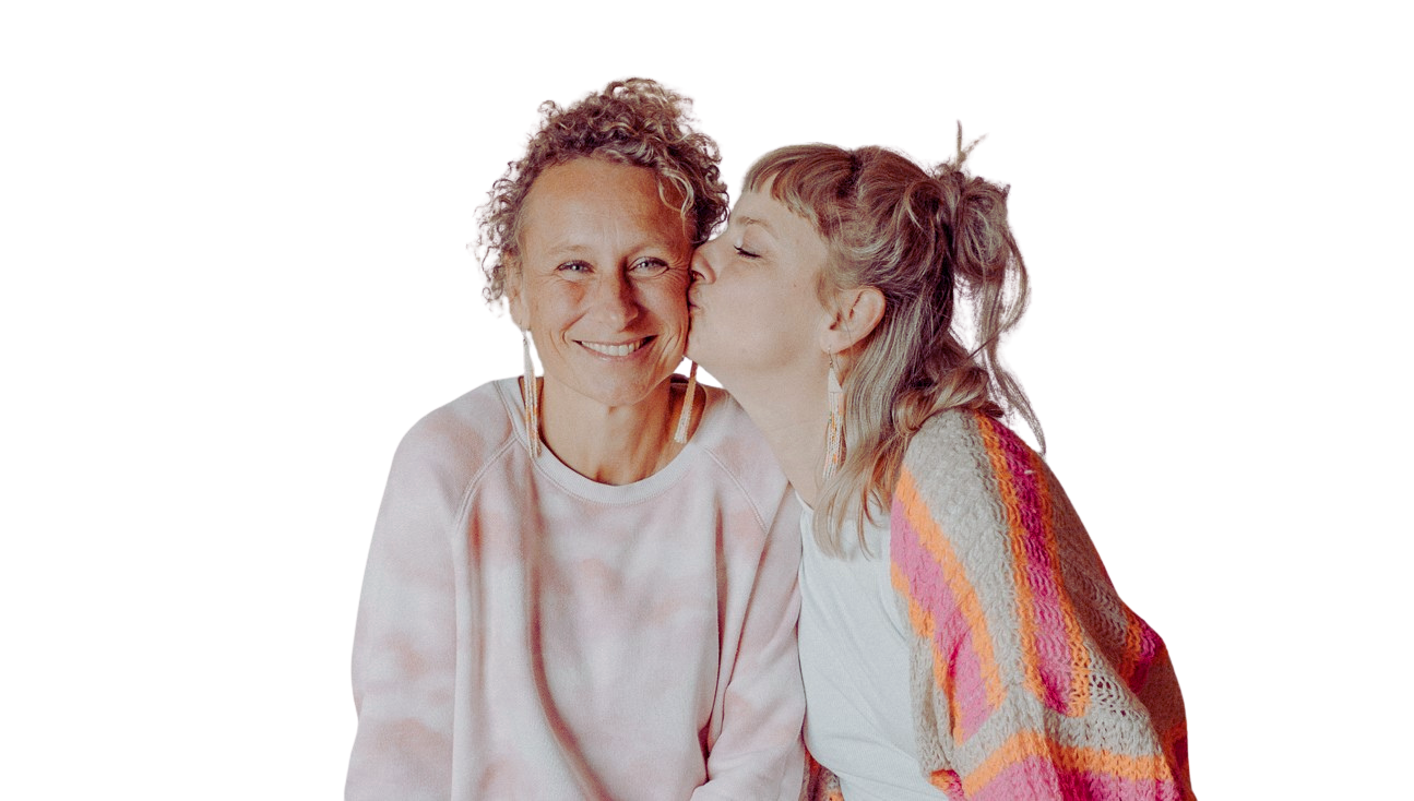 Zwei Frauen, eine ältere und eine jüngere, die sich küssen, lachend und lächelnd, Portrait, locker gekleidet.